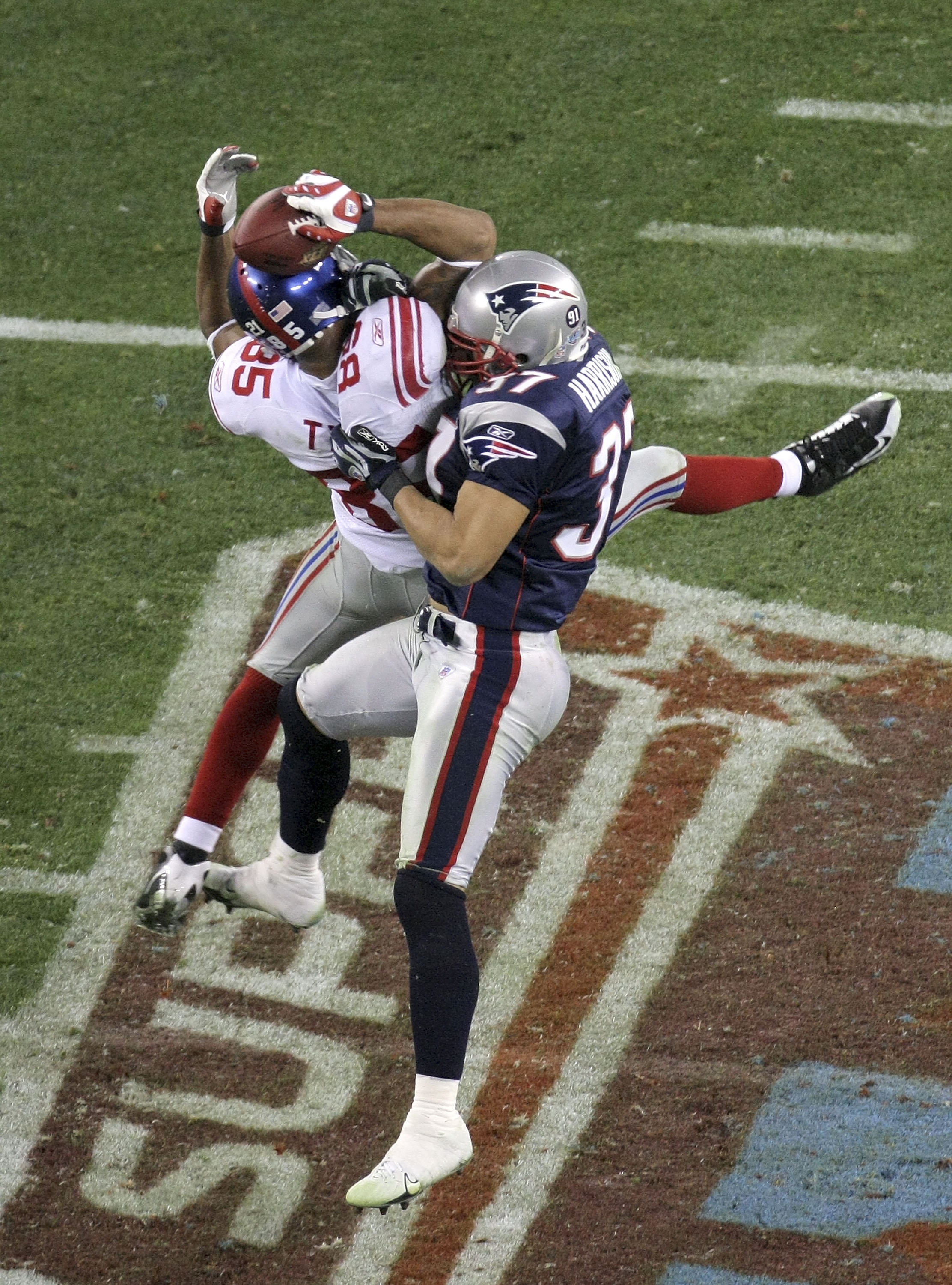 GLENDALE, AZ - FEBRUARY 03: David Tyree #85 of the New York Giants catches a 32-yard pass from Eli Manning #10 as Rodney Harrison #37 of the New England Patriots attempts to knock it out in the fourth quarter of Super Bowl XLII on February 3, 2008 at the GLENDALE, AZ - FEBRUARY 03: David Tyree #85 of the New York Giants catches a 32-yard pass from Eli Manning #10 as Rodney Harrison #37 of the New England Patriots attempts to knock it out in the fourth quarter of Super Bowl XLII on February 3, 2008 at the