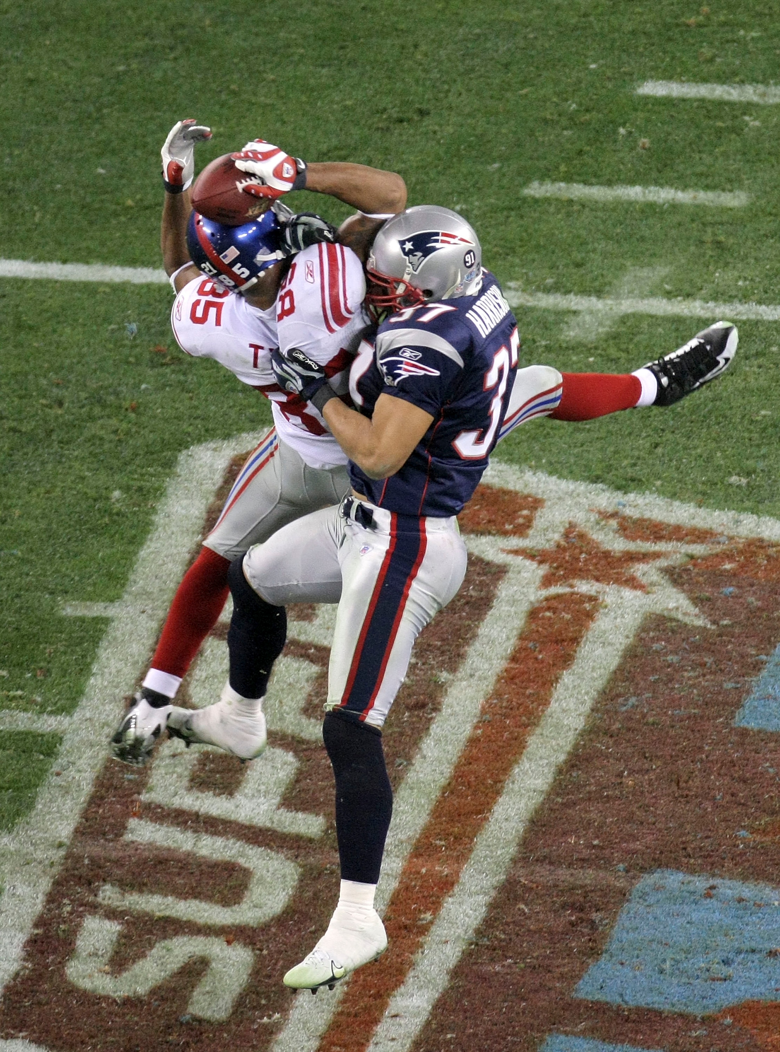 GLENDALE, AZ - FEBRUARY 03: David Tyree #85 of the New York Giants catches a 32-yard pass from Eli Manning #10 as Rodney Harrison #37 of the New England Patriots attempts to knock it out in the fourth quarter of Super Bowl XLII on February 3, 2008 at the GLENDALE, AZ - FEBRUARY 03: David Tyree #85 of the New York Giants catches a 32-yard pass from Eli Manning #10 as Rodney Harrison #37 of the New England Patriots attempts to knock it out in the fourth quarter of Super Bowl XLII on February 3, 2008 at the