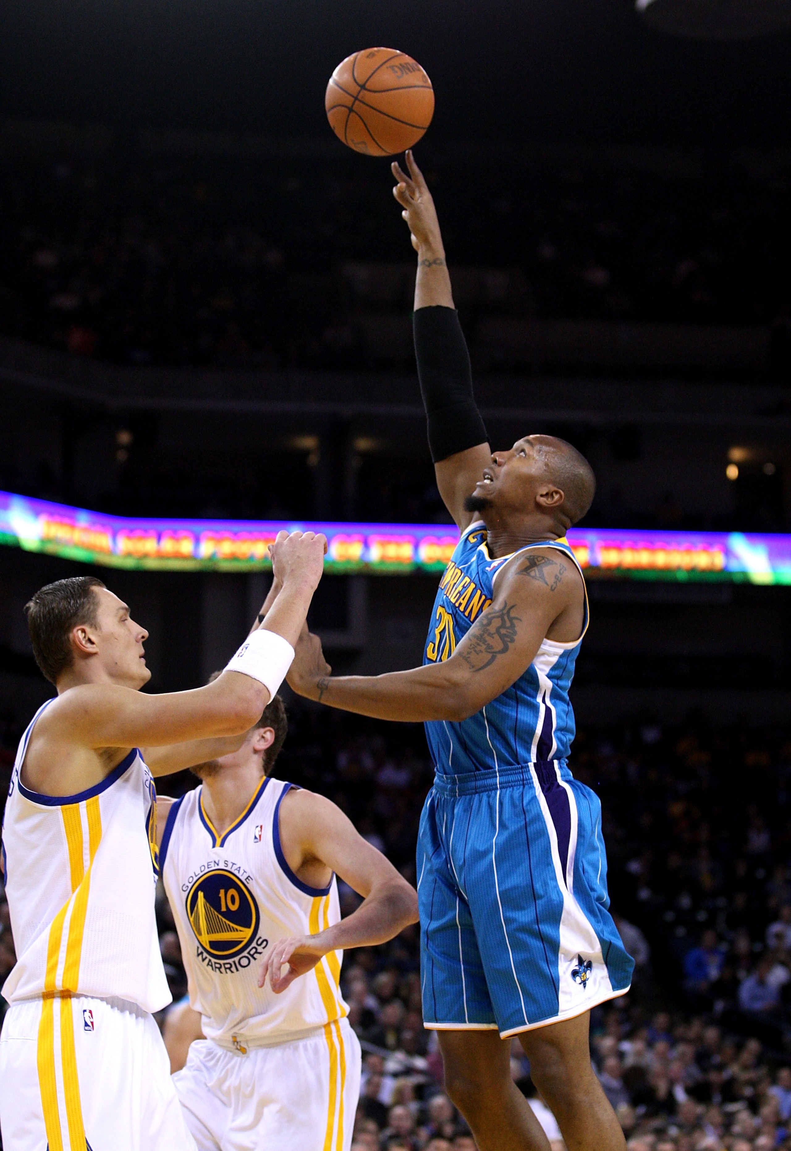 OAKLAND, CA - JANUARY 26:  David West #30 of the New Orleans Hornets shoots over Andris Biedrins #15 of the Golden State Warriors at Oracle Arena on January 26, 2011 in Oakland, California.  NOTE TO USER: User expressly acknowledges and agrees that, by do