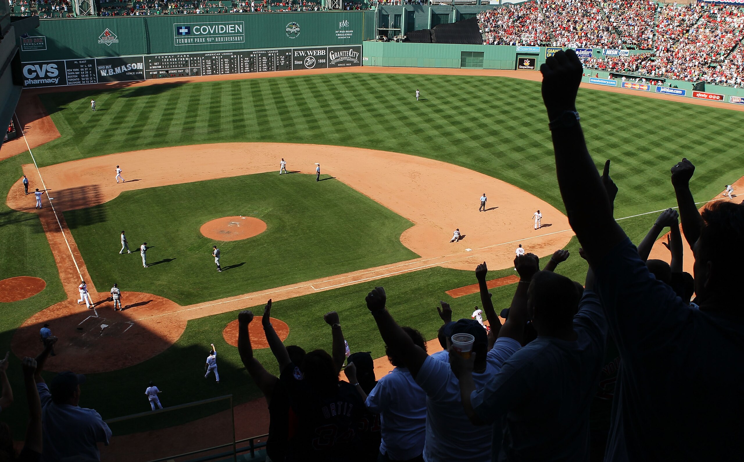 BOSTON - AUGUST 01:  Fans react as Darnell McDonald #54 of the Boston Red Sox scores the game winning run off a bunt by Marco Scutaro #16 in the bottom of the ninth inning against the Detroit Tigers on August 1, 2010 at Fenway Park in Boston, Massachusett