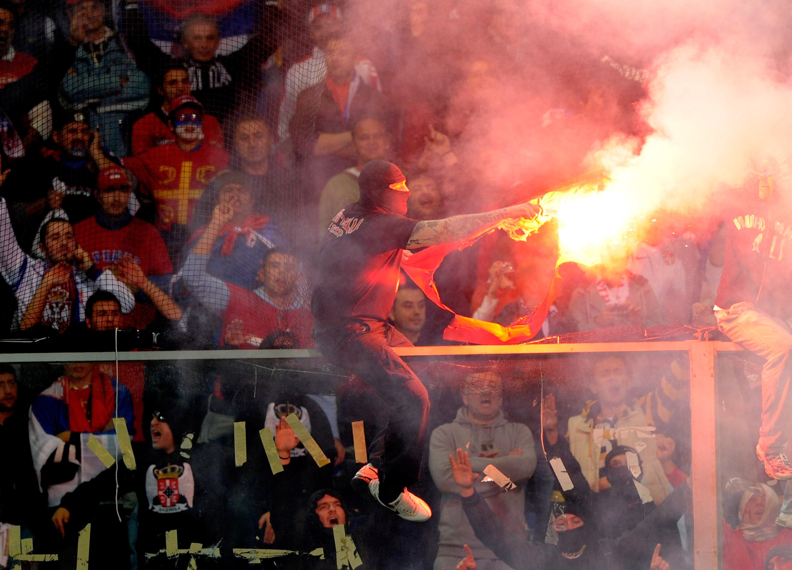 GENOA, ITALY - OCTOBER 12: Balaclava clad Serbian fan Ivan Bogdanov gestures towards riot police during the UEFA EURO 2012 Group C qualifier between Italy and Serbia at Luigi Ferraris Stadium on October 12, 2010 in Genoa, Italy. (Photo by Claudio Villa/Ge