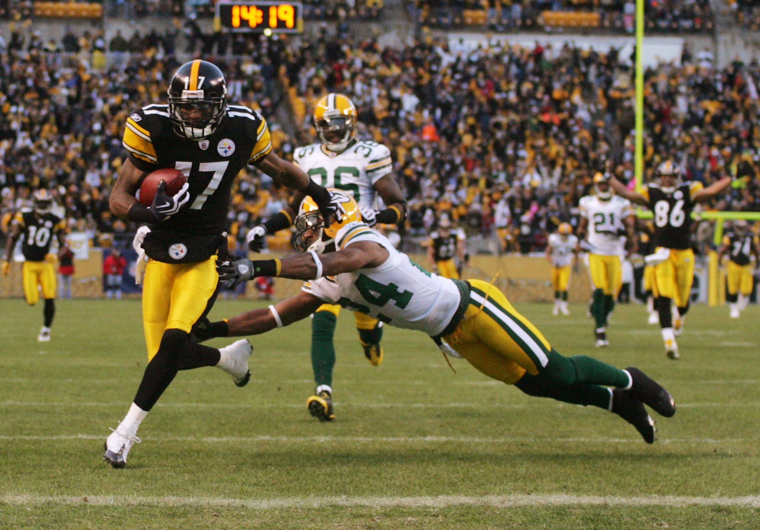 PITTSBURGH - DECEMBER 20:  Mike Wallace #17 of the Pittsburgh Steelers runs for a touchdown as Jarrett Bush #24 of the Green Bay Packers attempts to tackle in the first quarter during the game on December 20, 2009 at Heinz Field in Pittsburgh, Pennsylvani