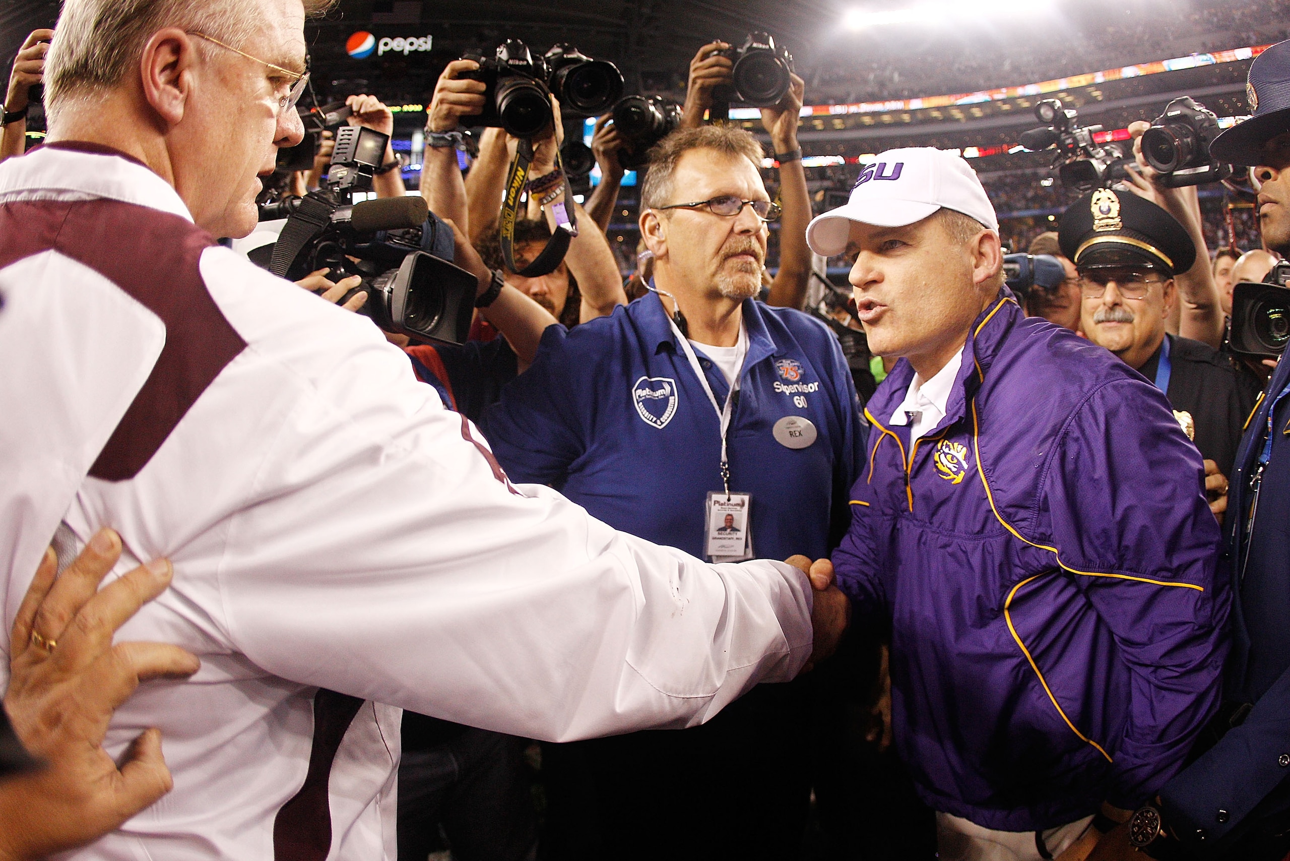 ARLINGTON, TX - JANUARY 07:  Head coach Les Miles of the Louisiana State University Tigers is congratulated by head coach Mike Sherman of the Texas A&M Aggies after the AT&T Cotton Bowl at Cowboys Stadium on January 7, 2011 in Arlington, Texas.  The Tiger