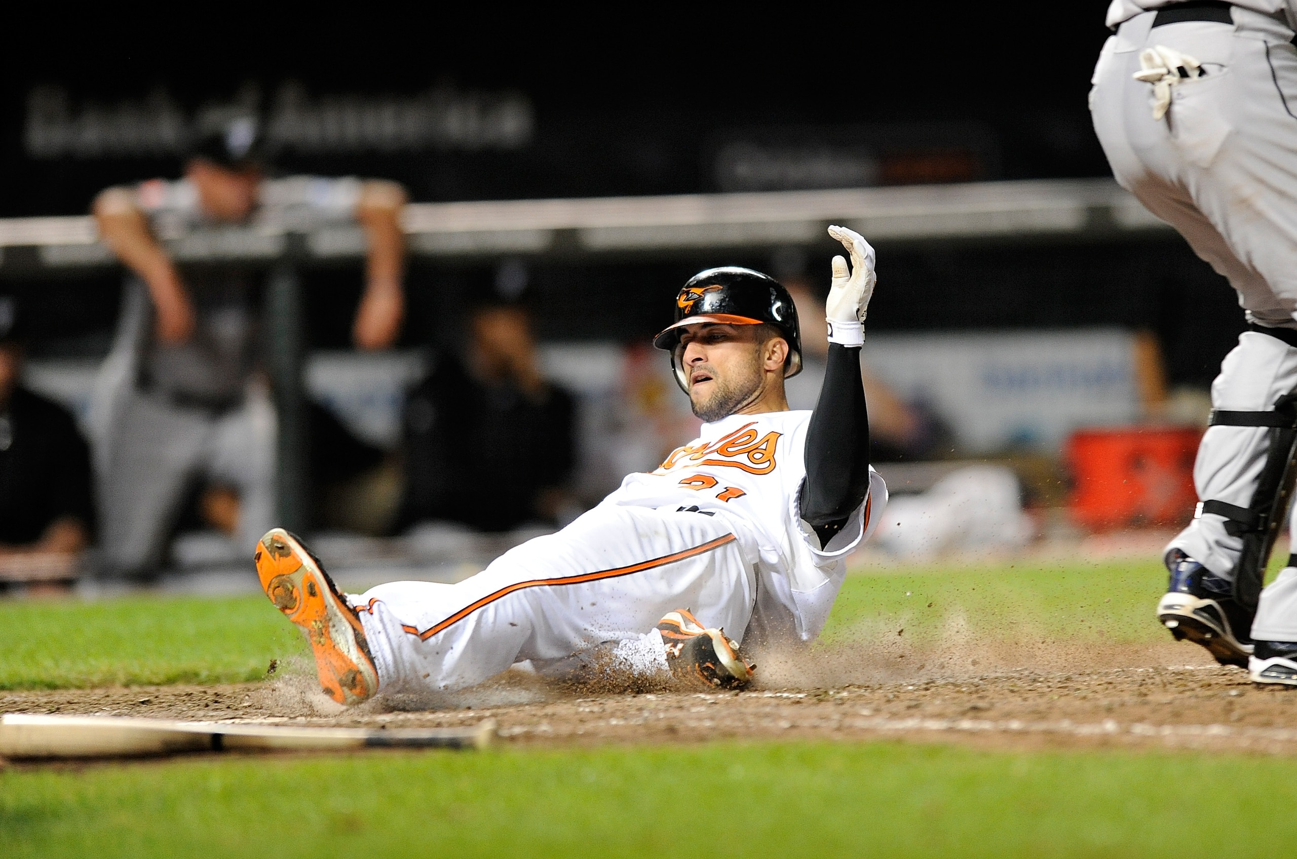 BALTIMORE - SEPTEMBER 13:  Nick Markakis #21 of the Baltimore Orioles slides into home plate with the winning run in the eleventh inning against the Toronto Blue Jays at Camden Yards on September 13, 2010 in Baltimore, Maryland. The Orioles won the game 4