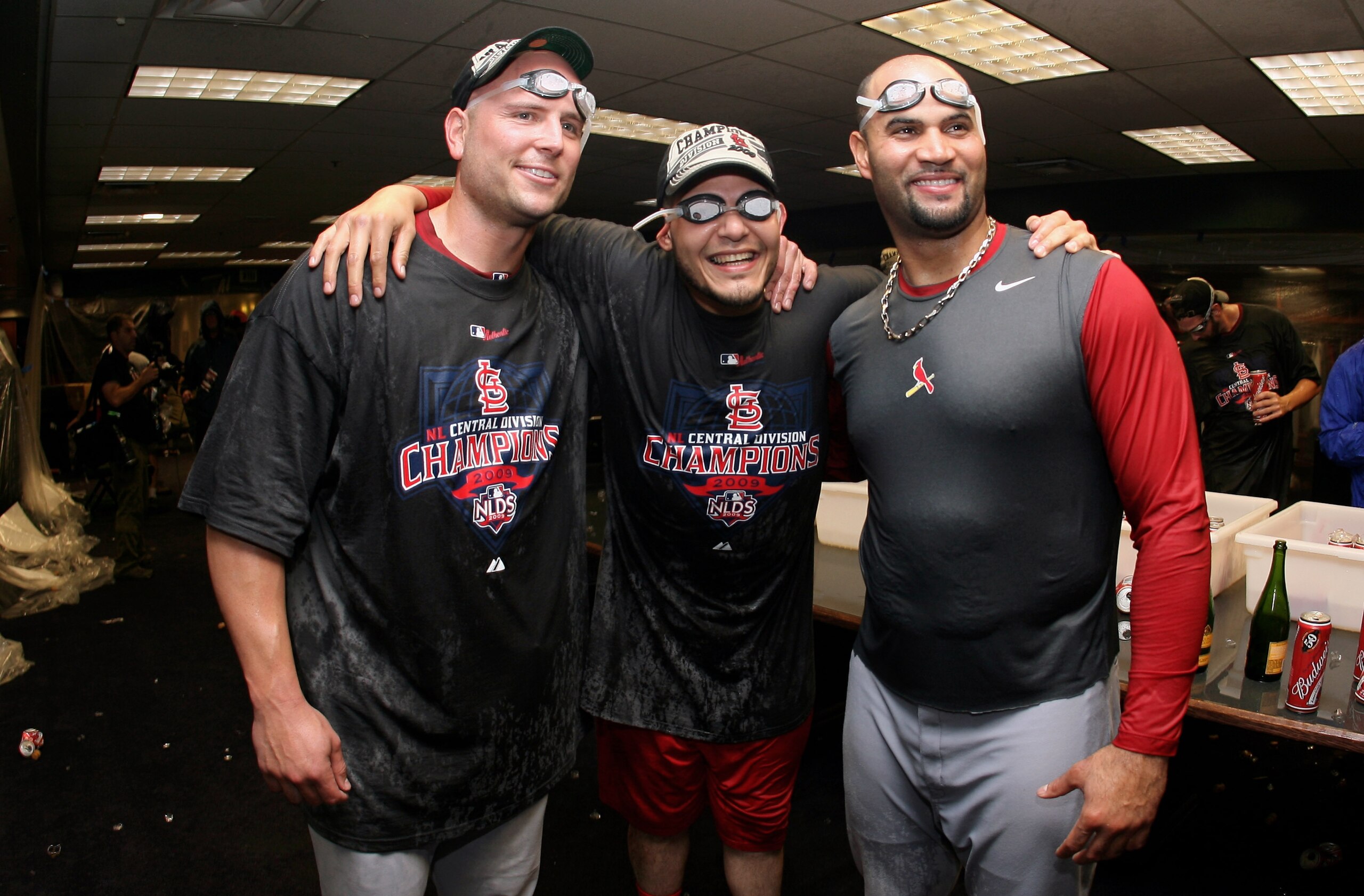 DENVER - SEPTEMBER 26:  (L-R) Matt Holliday, Yadier Molina and Albert Pujols of the St. Louis Cardinals celebrate clinching the National League Central Division after defeating the Colorado Rockies at Coors Field on September 26, 2009 in Denver, Colorado.