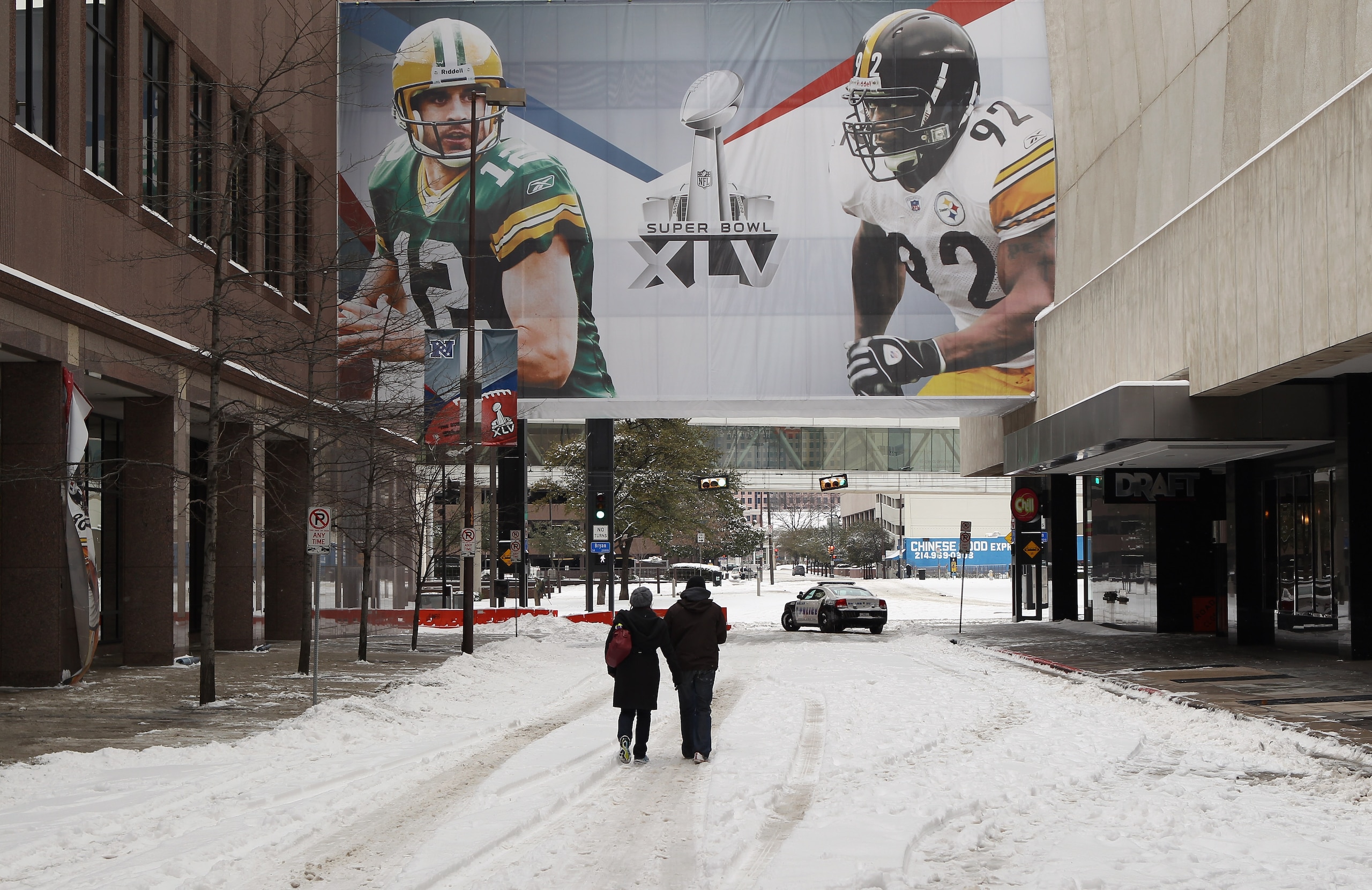 ARLINGTON, TX - FEBRUARY 04:  A couple walks down a snow covered street ahead of Super Bowl XLV at  on February 4, 2011 in Arlington, Texas.  (Photo by Streeter Lecka/Getty Images)