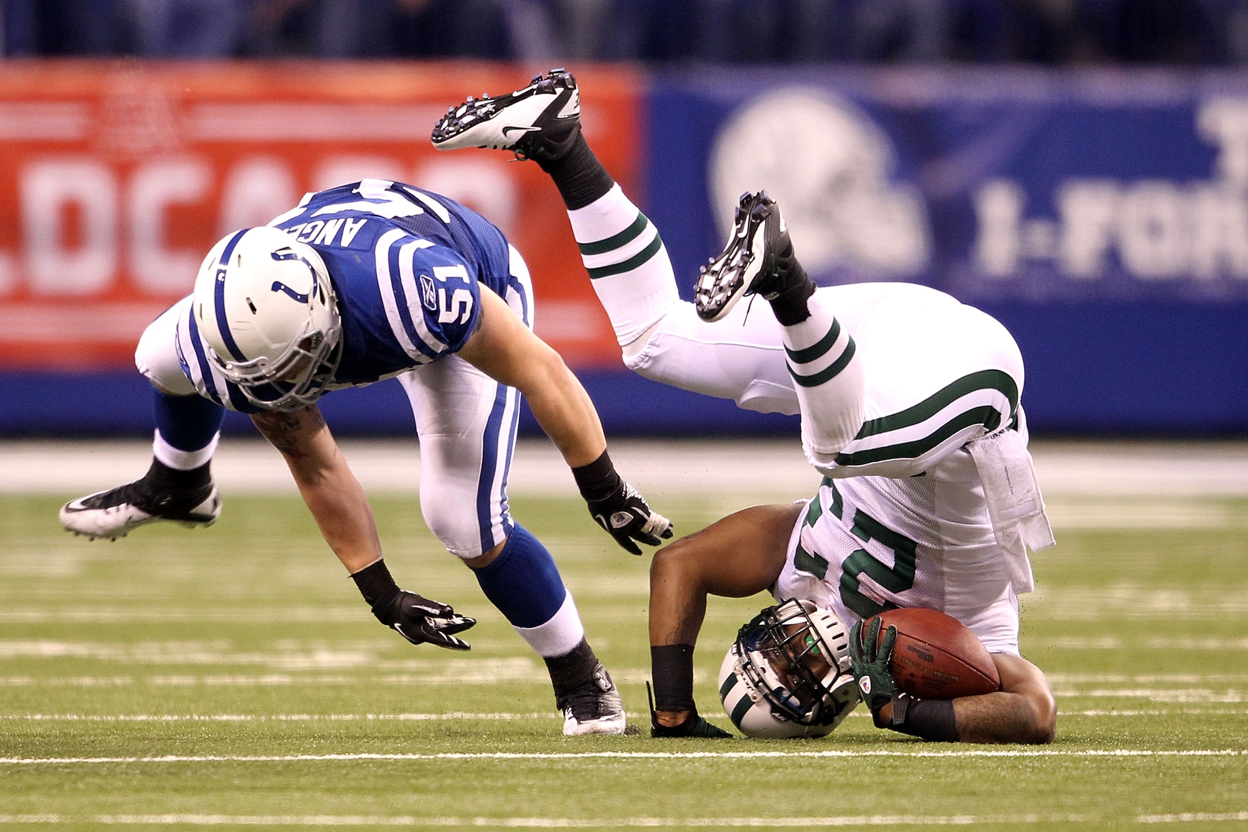 INDIANAPOLIS, IN - JANUARY 08:  Shonn Grenne #23 of the New York Jets rolls onto his head as he is stopped while running the ball by Pat Angerer #51 of the Indianapolis Colts during their 2011 AFC wild card playoff game at Lucas Oil Stadium on January 8,