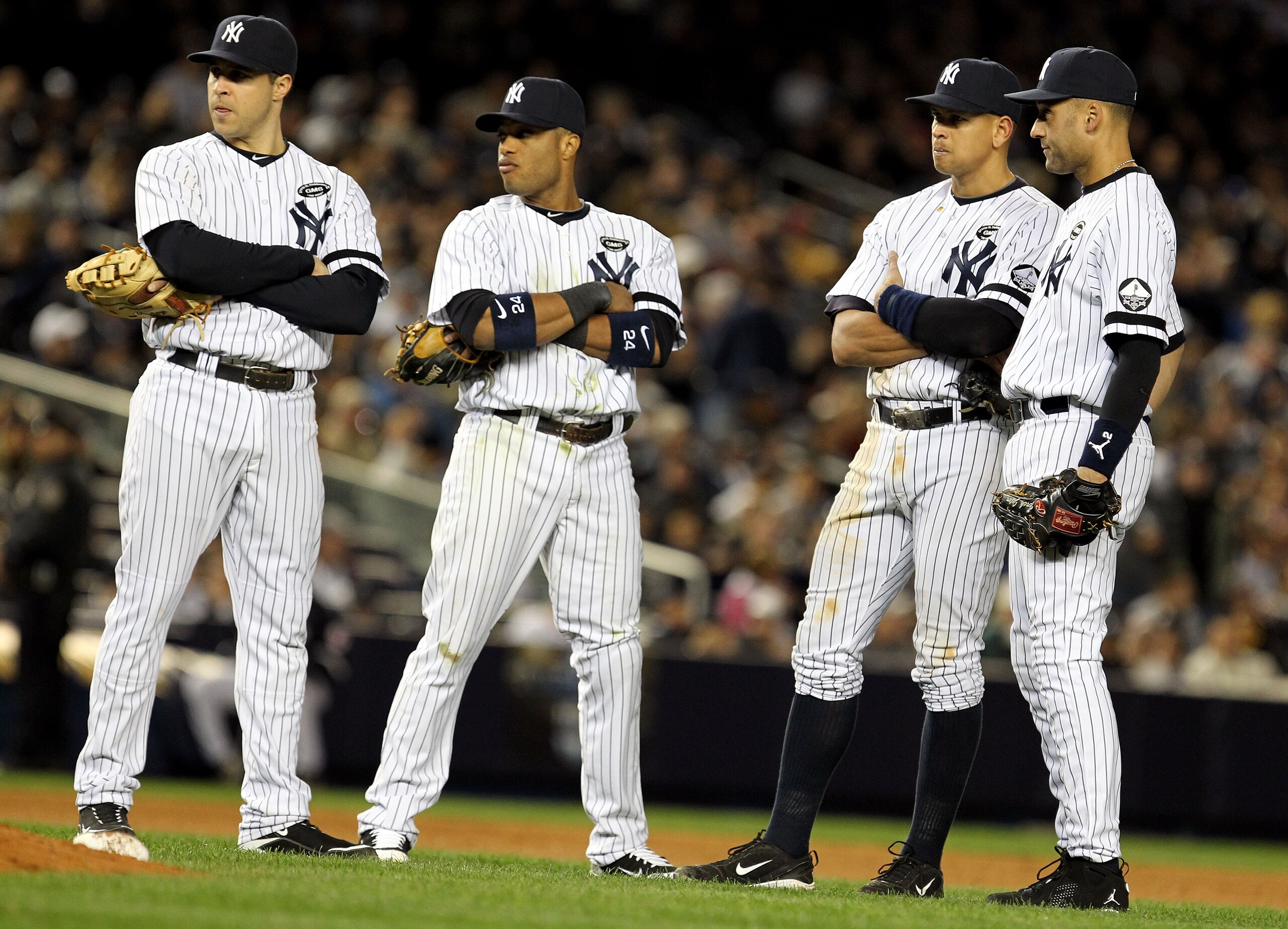 NEW YORK - OCTOBER 18:  Mark Teixeira #25, Robinson Cano #24, Alex Rodriguez #13 and Derek Jeter #2 of the New York Yankees look on during a pitching change against the Texas Rangers in Game Three of the ALCS during the 2010 MLB Playoffs at Yankee Stadium