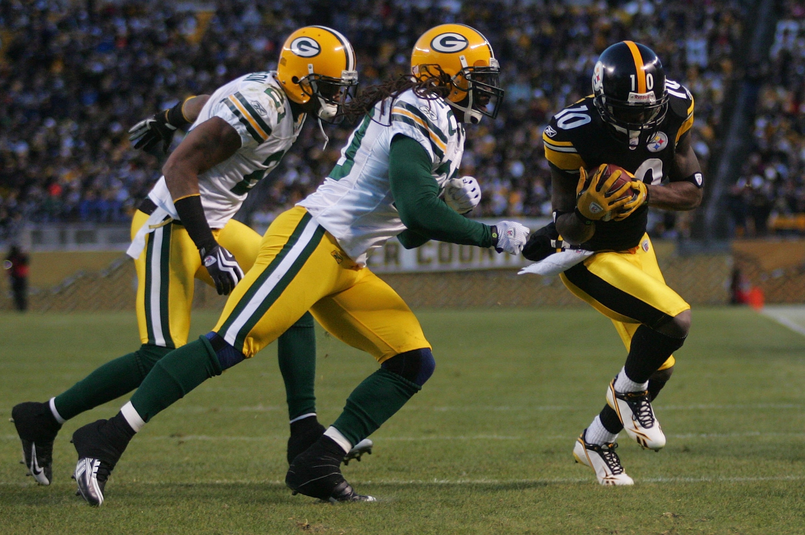 PITTSBURGH - DECEMBER 20: Santonio Holmes #10 of the Pittsburgh Steelers catches a pass in front of Atari Bigby #20 and Charles Woodson #21 of the Green Bay Packers during the game on December 20, 2009 at Heinz Field in Pittsburgh, Pennsylvania. (Photo PITTSBURGH - DECEMBER 20: Santonio Holmes #10 of the Pittsburgh Steelers catches a pass in front of Atari Bigby #20 and Charles Woodson #21 of the Green Bay Packers during the game on December 20, 2009 at Heinz Field in Pittsburgh, Pennsylvania. (Photo