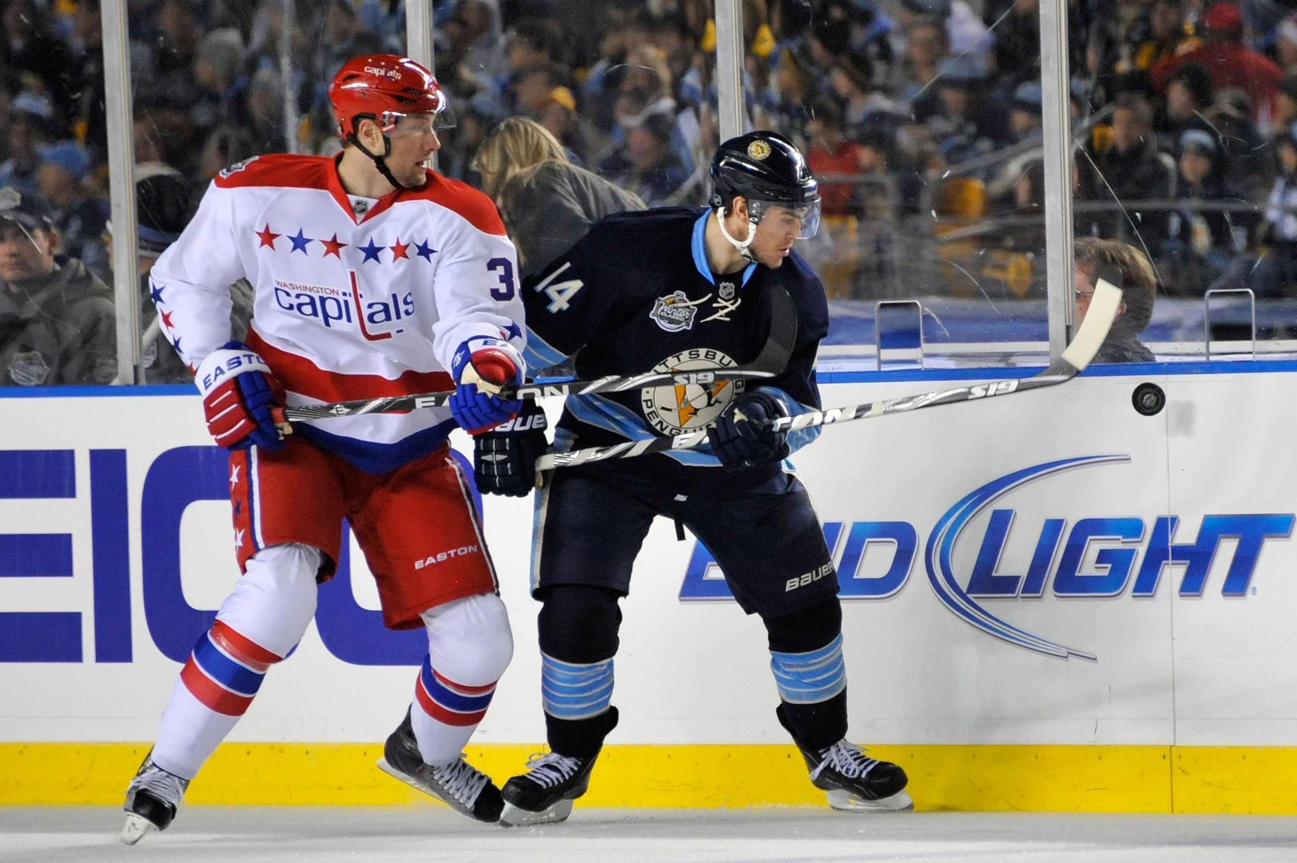 PITTSBURGH, PA - JANUARY 01:  Chris Kunitz #14 of the Pittsburgh Penguins battles for control of the puck against David Steckel #39 of the Washington Capitals during the 2011 NHL Bridgestone Winter Classic at Heinz Field on January 1, 2011 in Pittsburgh,
