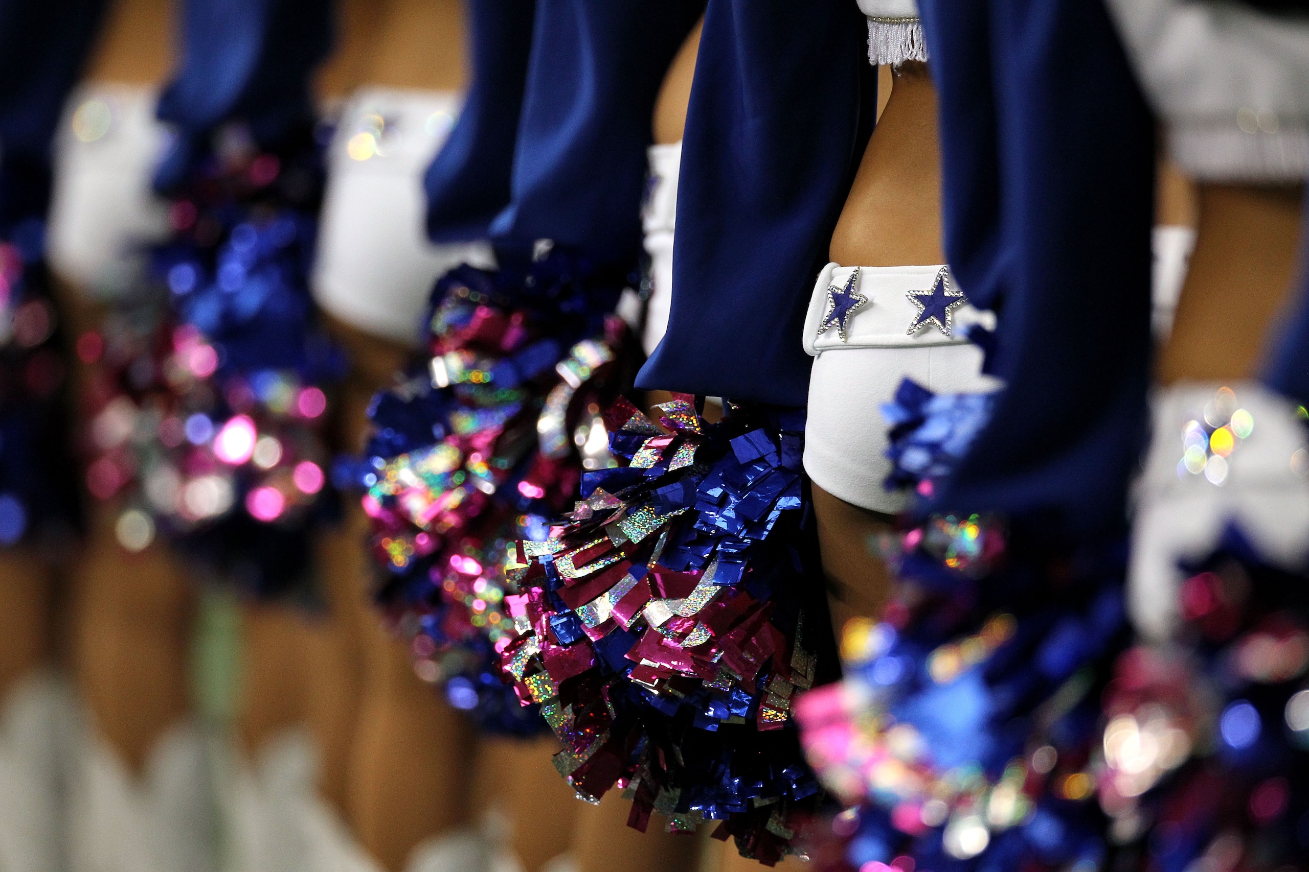 ARLINGTON, TX - OCTOBER 31:  A detail the Dallas Cowboys cheerleaders as they line up holding pom poms against the Jacksonville Jaguars at Cowboys Stadium on October 31, 2010 in Arlington, Texas.  (Photo by Ronald Martinez/Getty Images)