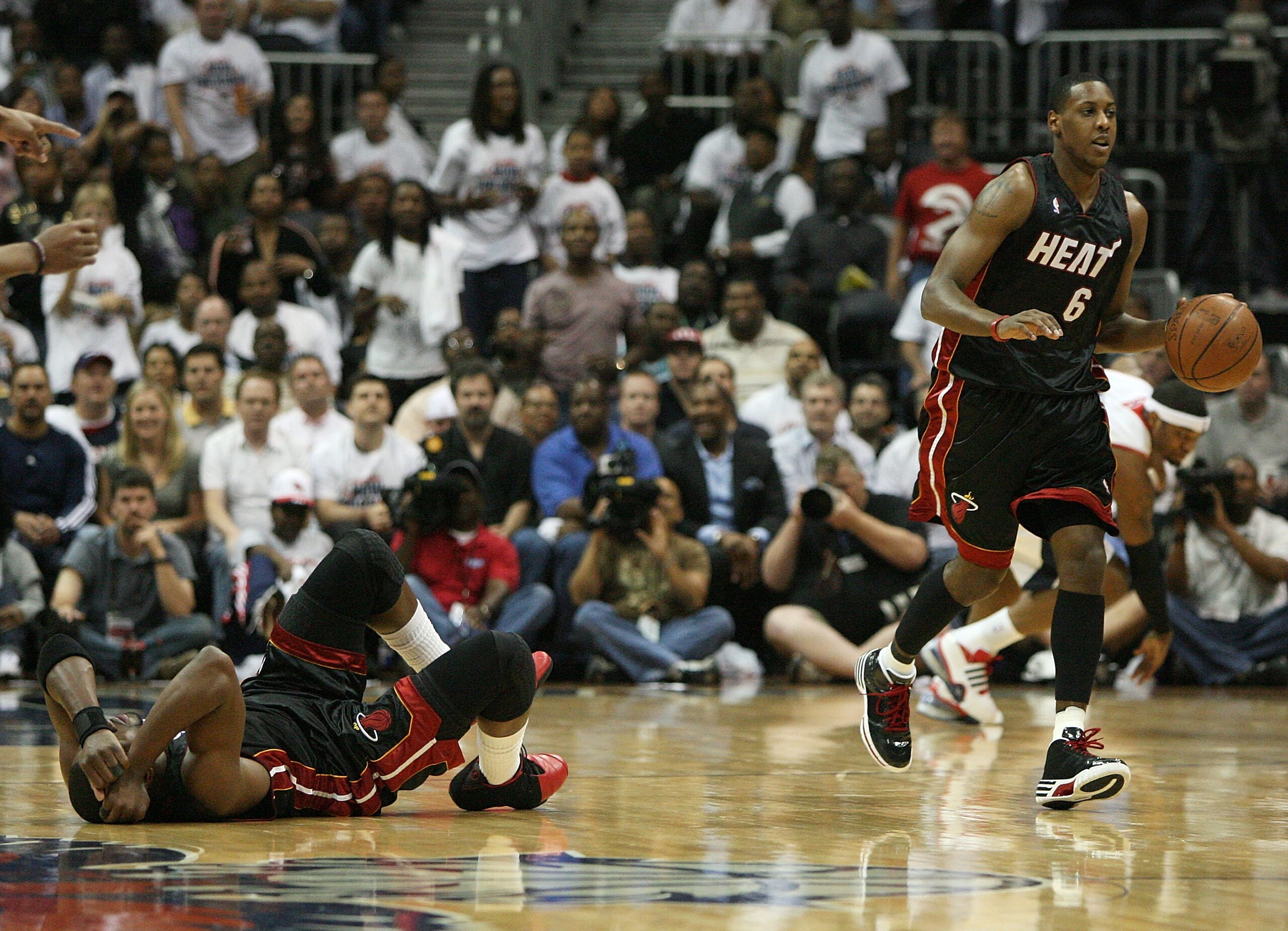 ATLANTA - APRIL 29:  Dwyane Wade #3 of the Miami Heat holds his head as teammate Mario Chalmers #6 continues play after colliding with Josh Smith #5 of the Atlanta Hawks during Game Five of the Eastern Conference Quarterfinals at Philips Arena on April 29