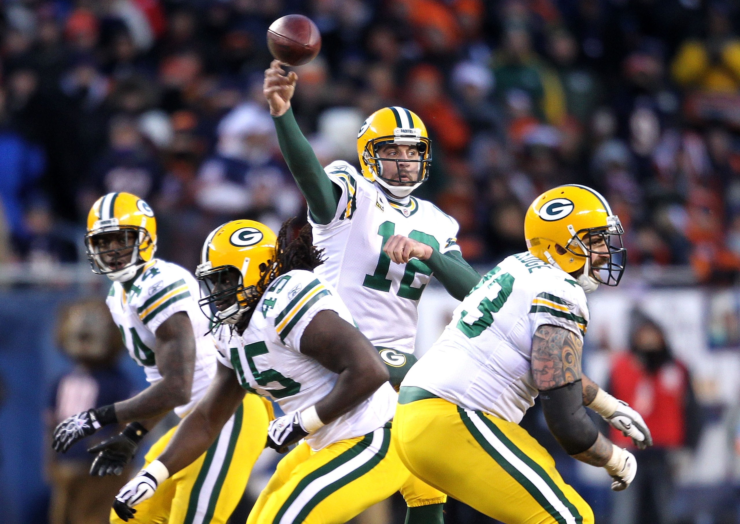 CHICAGO, IL - JANUARY 23:  Quarterback Aaron Rodgers #12 of the Green Bay Packers throws the ball as James Starks #44, Quinn Johnson #45 and Scott Wells #63 block while taking on the Chicago Bears in the NFC Championship Game at Soldier Field on January 2