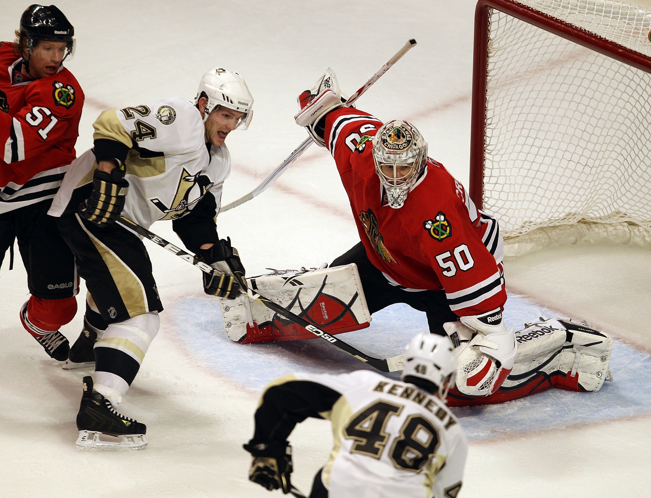 CHICAGO, IL - FEBRUARY 20: Corey Crawford #50 of the Chicago Blackhawks looks to make a save against Tyler Kennedy #48 and Matt Cooke #24 of the Pittsburgh Penguins at the United Center on February 20, 2011 in Chicago, Illinois. The Blackhawks defeated th