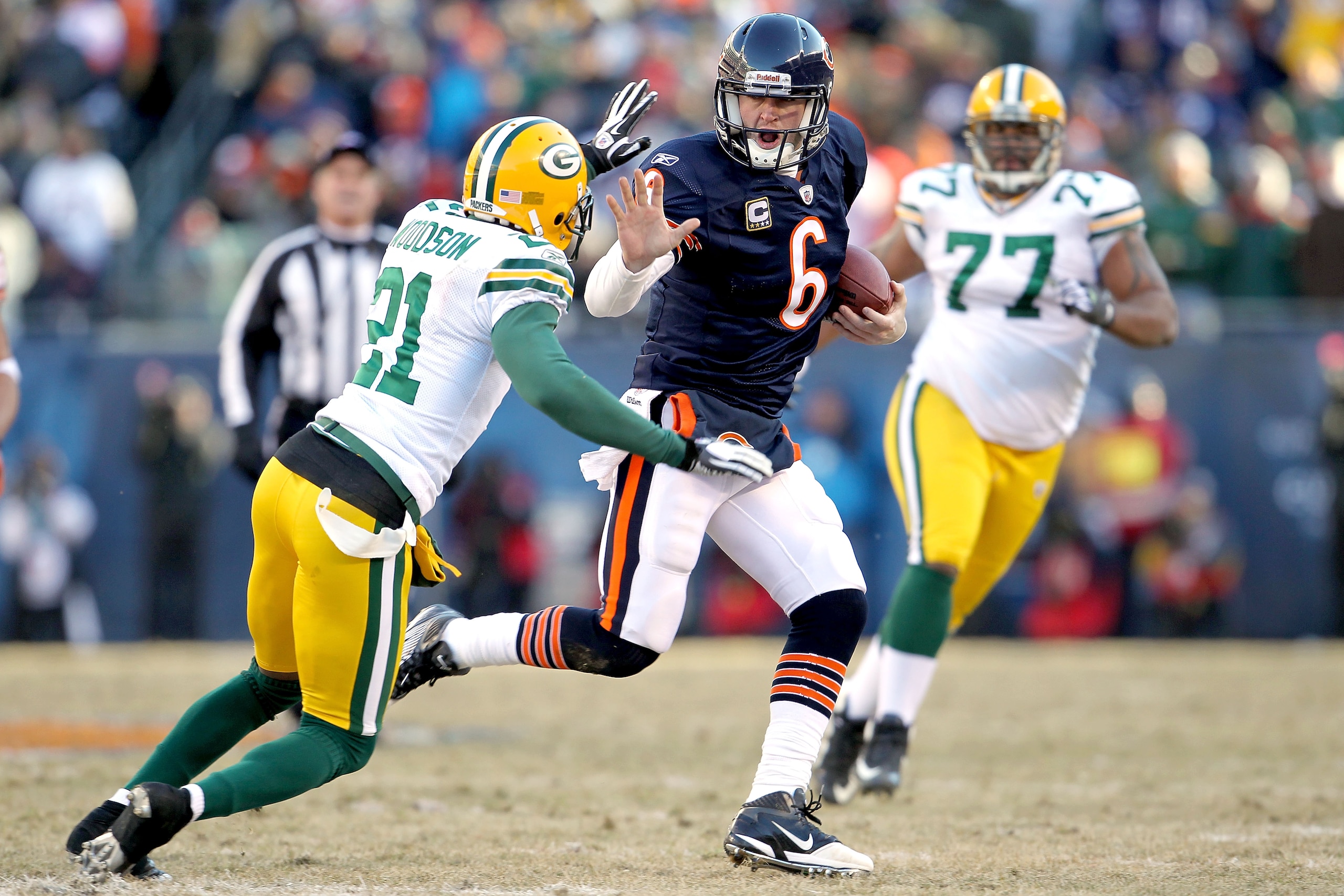 CHICAGO, IL - JANUARY 23:  Quarterback Jay Cutler #6 of the Chicago Bears throws out his right arm to avoid a tackle by Charles Woodson #21 of the Green Bay Packers in the second quarter of the NFC Championship Game at Soldier Field on January 23, 2011 in