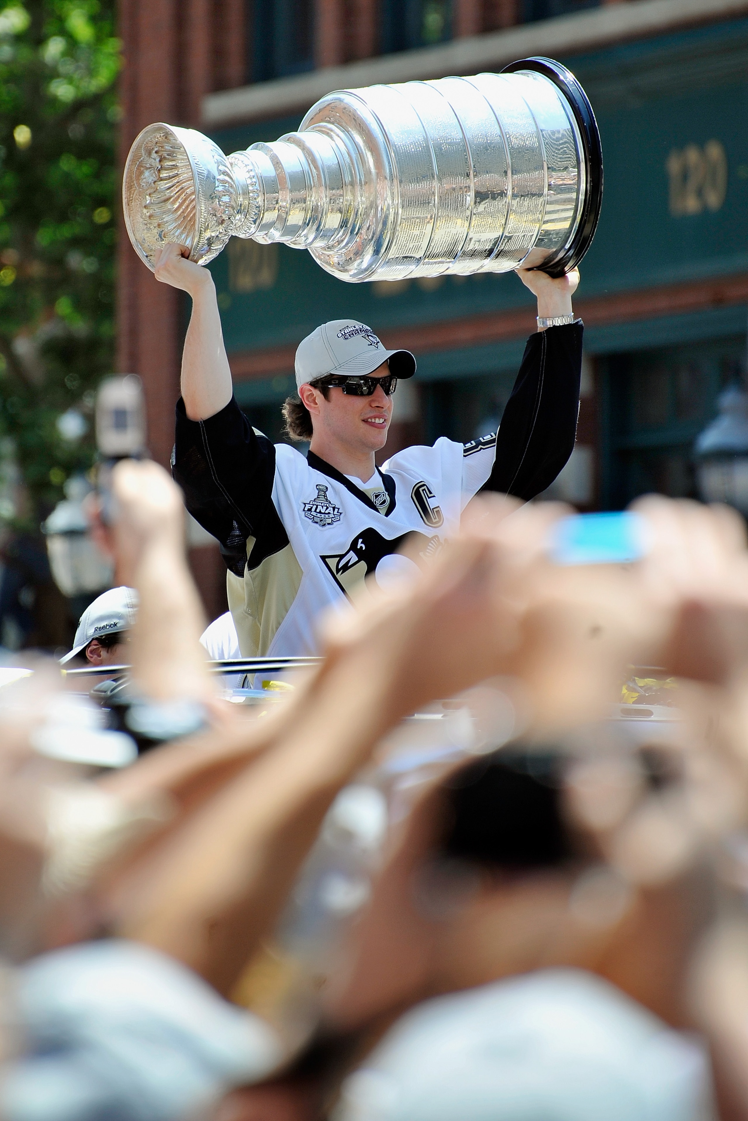 PITTSBURGH - JUNE 15:  Sidney Crosby #87 of the Pittsburgh Penguins holds aloft the Stanley Cup for the crowd on the Blvd of the Allies during Stanley Cup Champion Victory Parade on June 15, 2009 in Pittsburgh, Pennsylvania.  (Photo by Jamie Sabau/Getty I