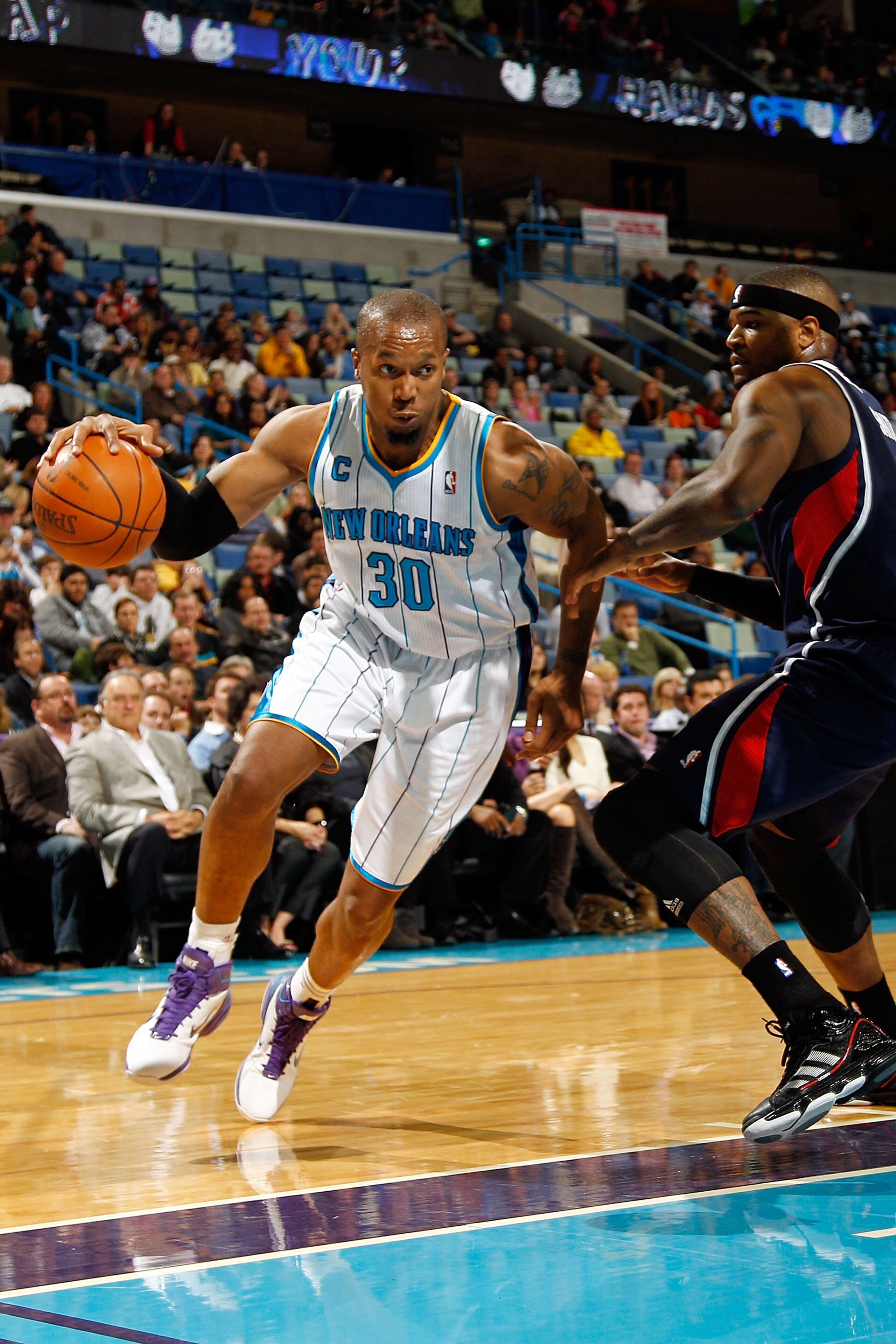 NEW ORLEANS, LA - DECEMBER 26: David West #30 of the New Orleans Hornets drives the ball around Josh Smith #5 of the Atlanta Hawks at the New Orleans Arena on December 26, 2010 in New Orleans, Louisiana. The Hornets defeated the Hawks 93-86. NOTE TO US NEW ORLEANS, LA - DECEMBER 26: David West #30 of the New Orleans Hornets drives the ball around Josh Smith #5 of the Atlanta Hawks at the New Orleans Arena on December 26, 2010 in New Orleans, Louisiana. The Hornets defeated the Hawks 93-86. NOTE TO US