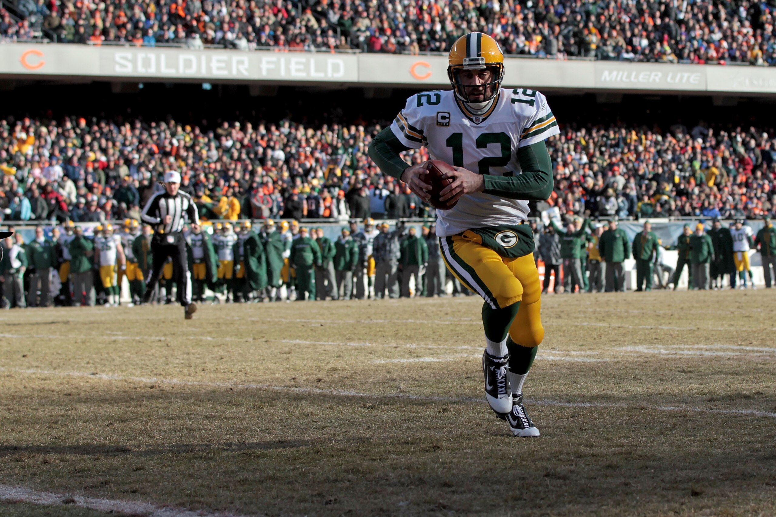 CHICAGO, IL - JANUARY 23:  Quarterback Aaron Rodgers #12 of the Green Bay Packers dives into the corner of the endzone for a one-yard touchdown run against Danieal Manning #38 of the Chicago Bears in the first quarter of the NFC Championship Game at Soldi