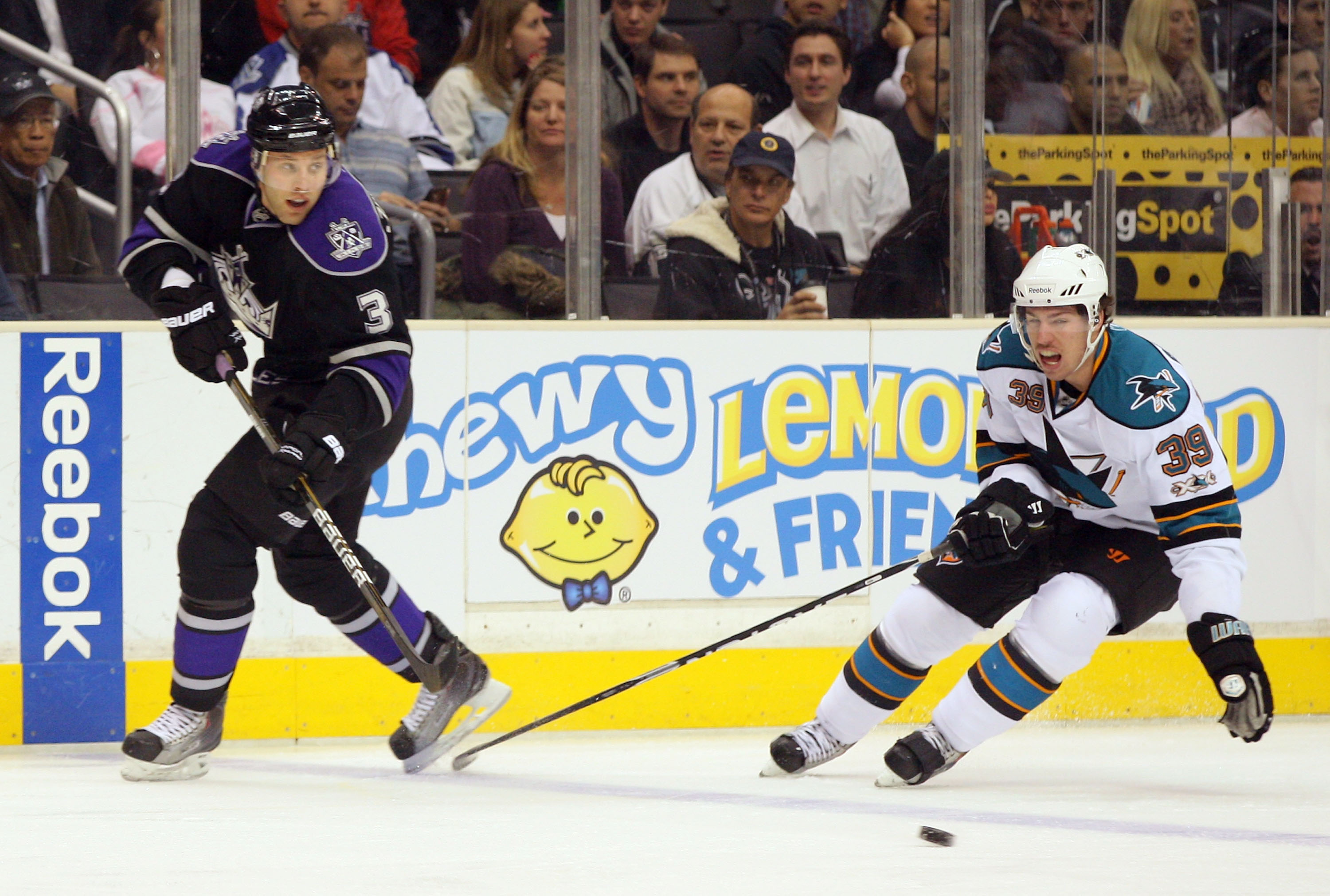 LOS ANGELES, CA - JANUARY 26:  Jack Johnson #3 of the Los Angeles Kings makes a backhand pass at the blueline under pressure from Logan Couture #39 of the San Jose Sharks during their NHL game at Staples Center on January 26, 2011 in Los Angeles, Californ