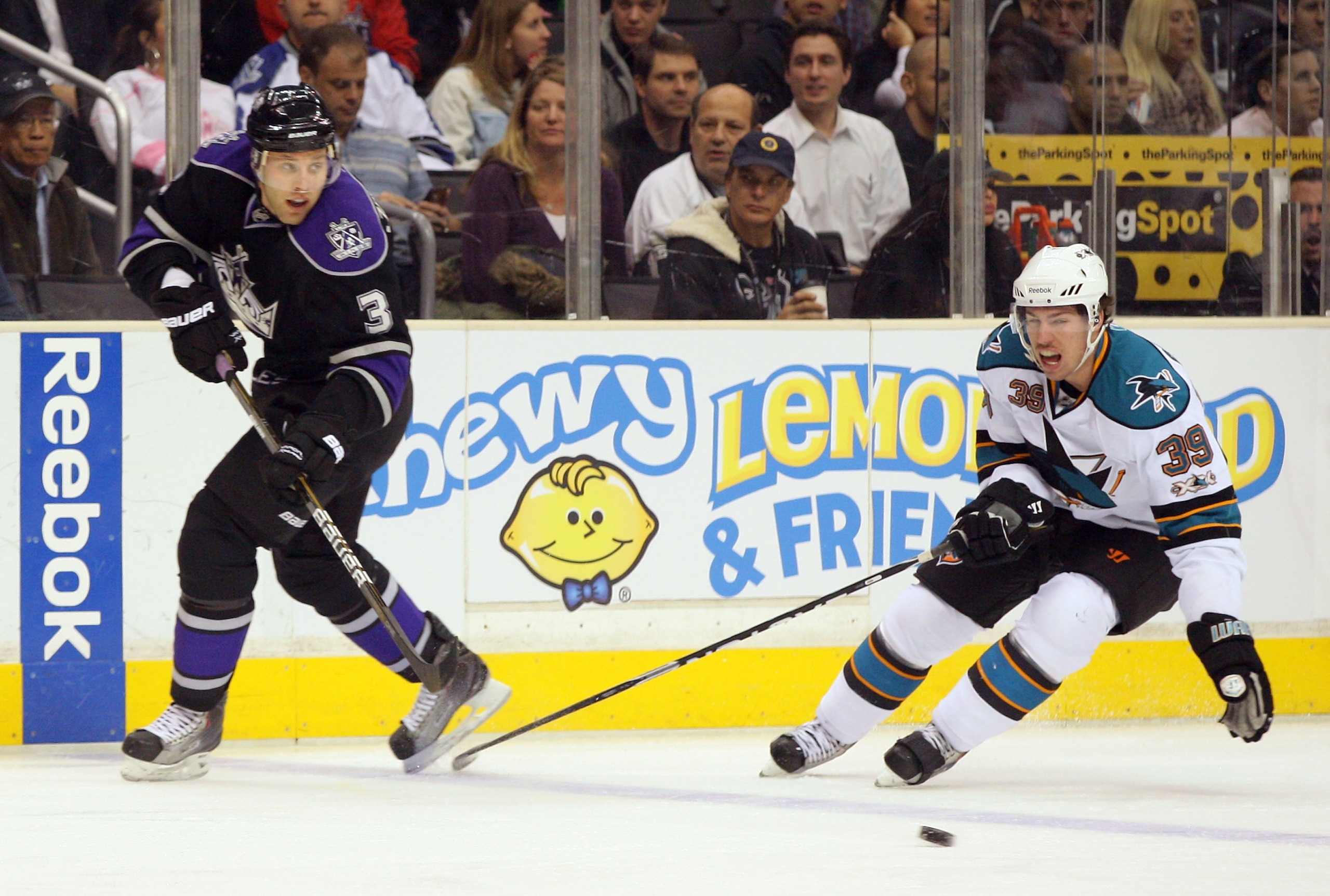 LOS ANGELES, CA - JANUARY 26:  Jack Johnson #3 of the Los Angeles Kings makes a backhand pass at the blueline under pressure from Logan Couture #39 of the San Jose Sharks during their NHL game at Staples Center on January 26, 2011 in Los Angeles, Californ