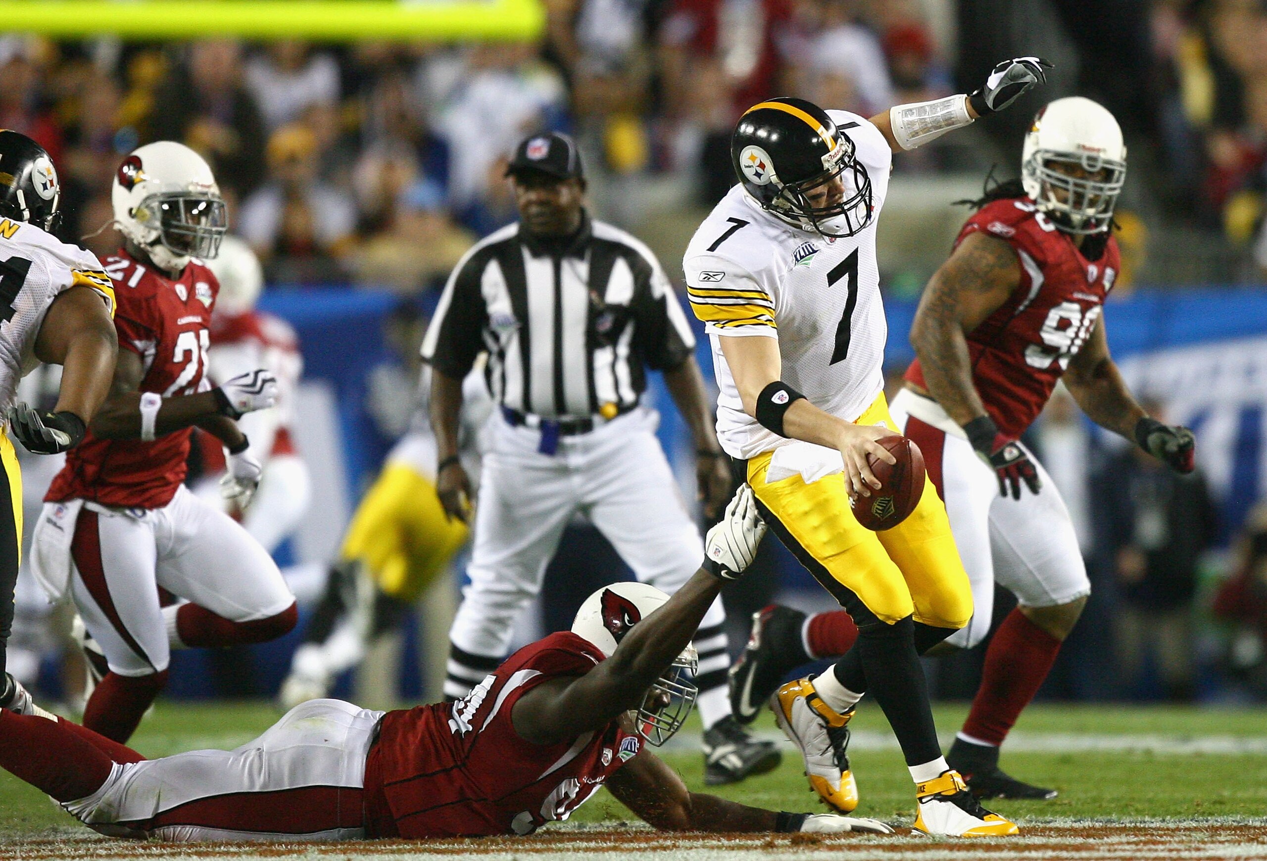 TAMPA, FL - FEBRUARY 01:  Quarterback Ben Roethlisberger #7 of the Pittsburgh Steelers scrambles in the first quarter against Antonio Smith #94 of the Arizona Cardinals during Super Bowl XLIII on February 1, 2009 at Raymond James Stadium in Tampa, Florida