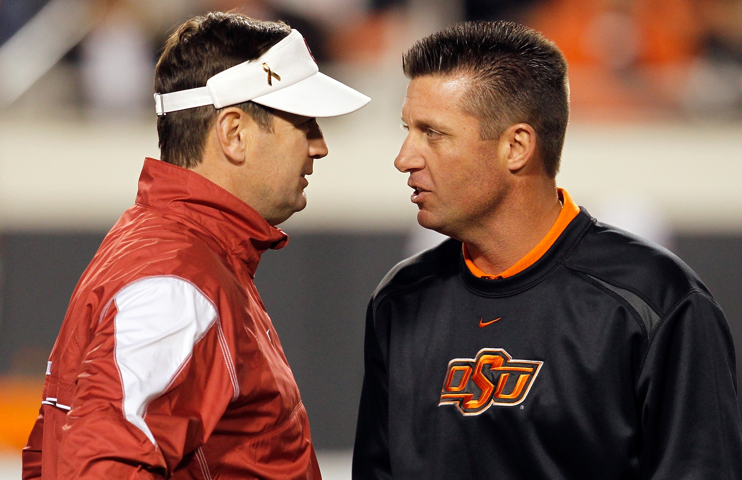 STILLWATER, OK - NOVEMBER 27:  Head coach Bob Stoops (L) of the Oklahoma Sooners talks with head coach Mike Gundy (R) of the Oklahoma State Cowboys at Boone Pickens Stadium on November 27, 2010 in Stillwater, Oklahoma.  (Photo by Tom Pennington/Getty Imag