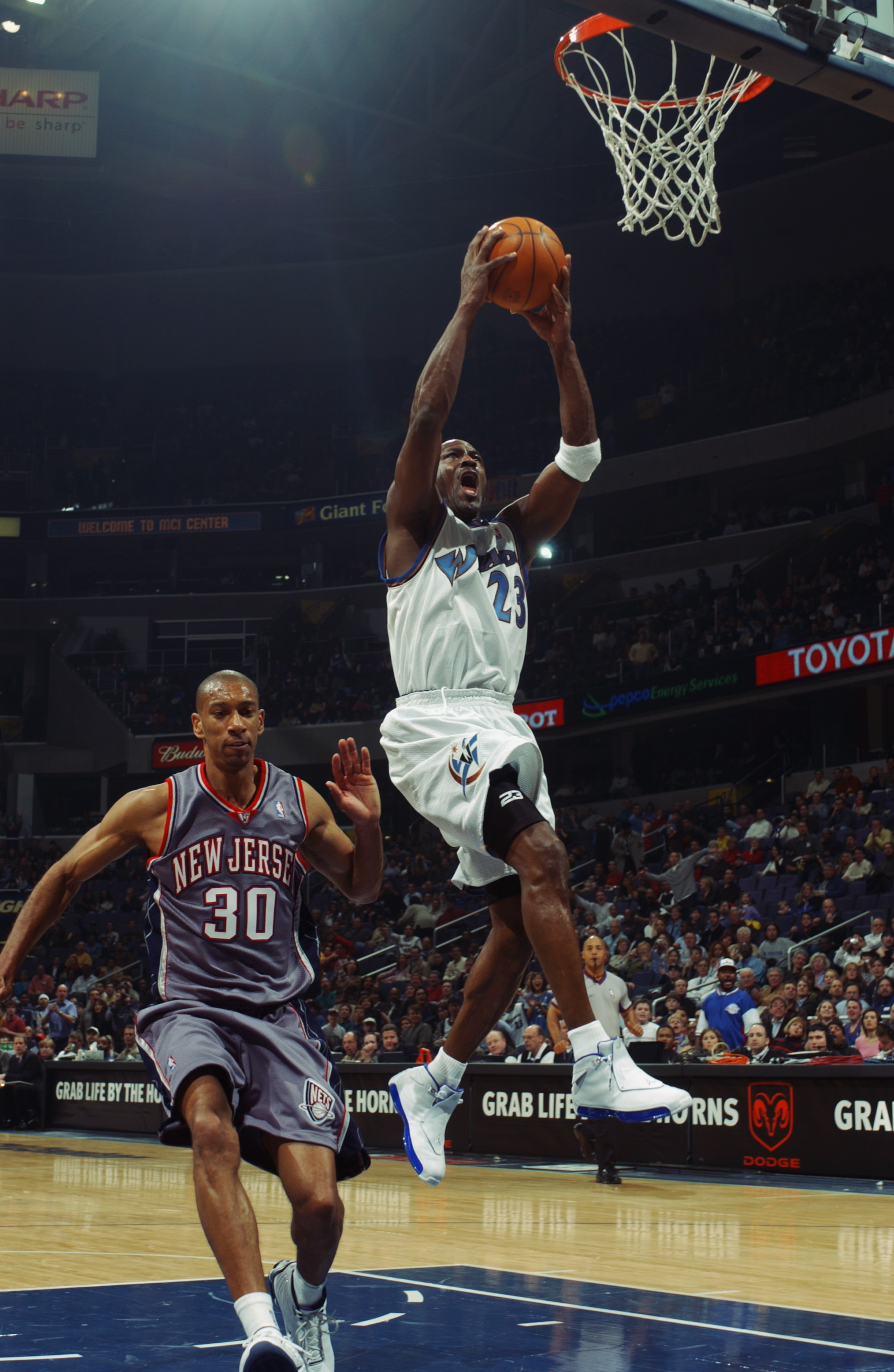 WASHINGTON - FEBRUARY 21:  Michael Jordan #23 of the Washington Wizards takes the ball to the basket past Kerry Kittles #30 of the New Jersey Nets during the NBA game at MCI Center on February 21, 2003 in Washington, D.C.  The Wizards won 89-86.  NOTE TO