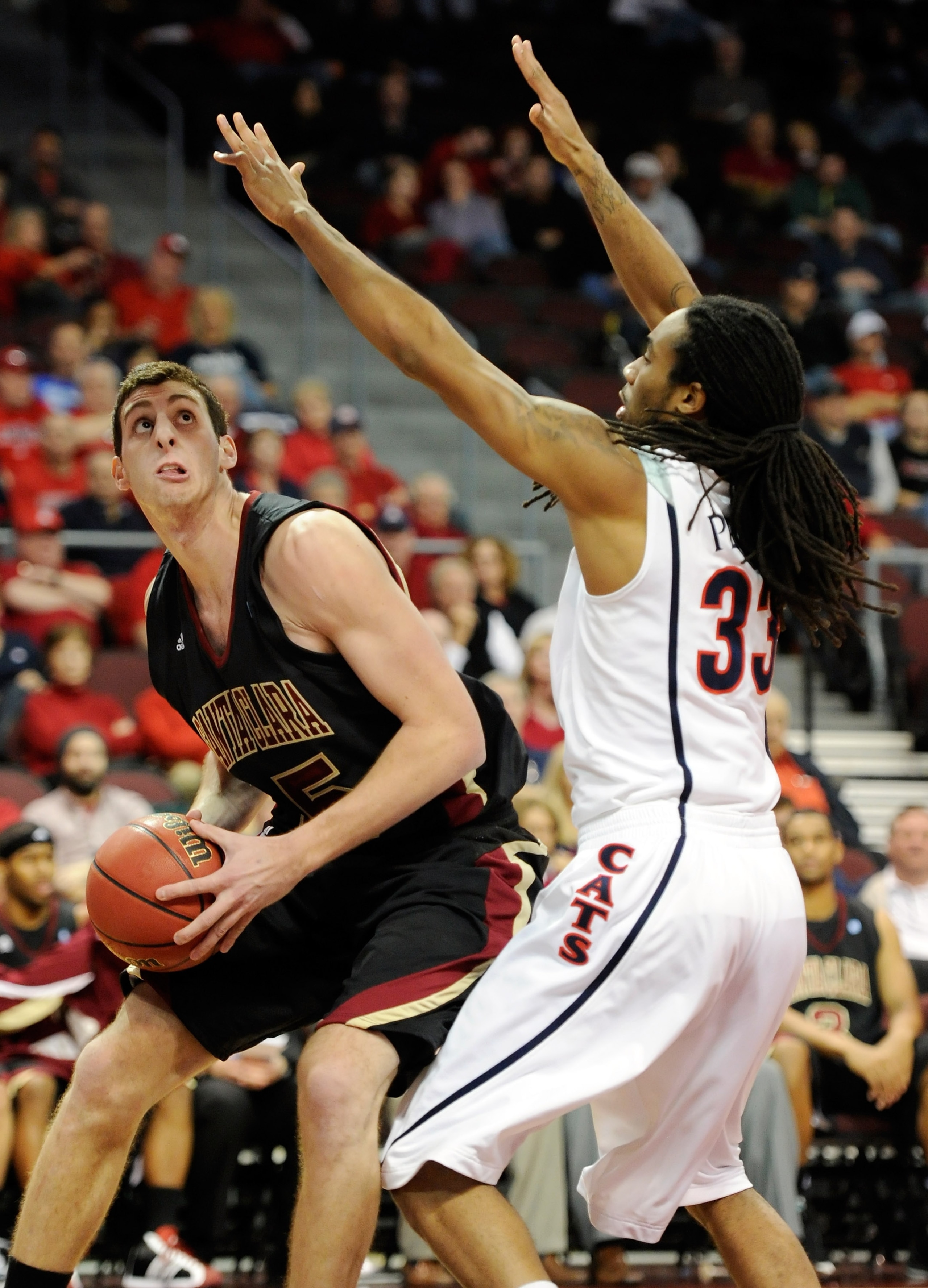 LAS VEGAS - NOVEMBER 26:  Marc Trasolini #15 of the Santa Clara Broncos drives against Jesse Perry #33 of the Arizona Wildcats during the third round of the Las Vegas Invitational at The Orleans Arena November 26, 2010 in Las Vegas, Nevada. Arizona won 82