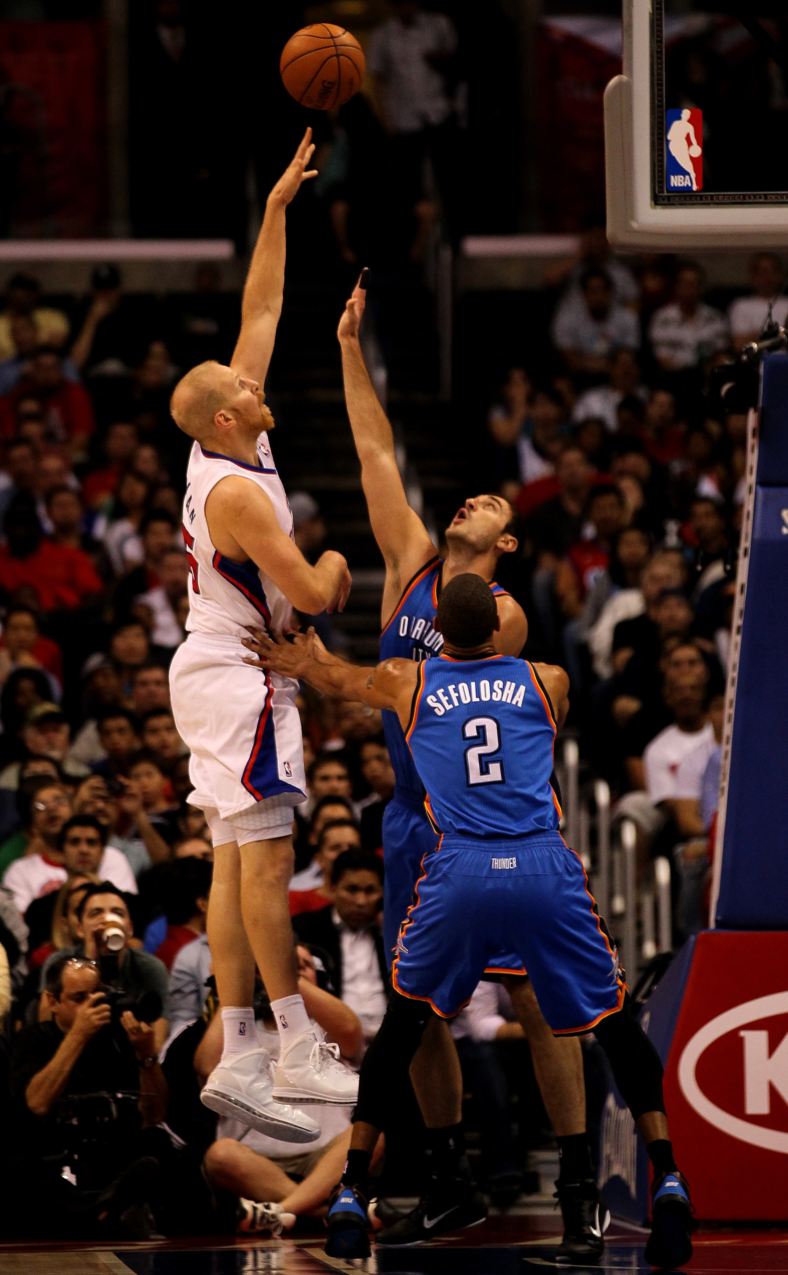 LOS ANGELES - NOVEMBER 3: Chris Kaman #35 of the Los Angeles Clippers shoots over Nenad Krstic #12 and Thabo Sefolosha #2 of the Oklahoma City Thunder at Staples Center on November 3, 2010 in Los Angeles, California. NOTE TO USER: User expressly acknowl LOS ANGELES - NOVEMBER 3: Chris Kaman #35 of the Los Angeles Clippers shoots over Nenad Krstic #12 and Thabo Sefolosha #2 of the Oklahoma City Thunder at Staples Center on November 3, 2010 in Los Angeles, California. NOTE TO USER: User expressly acknowl