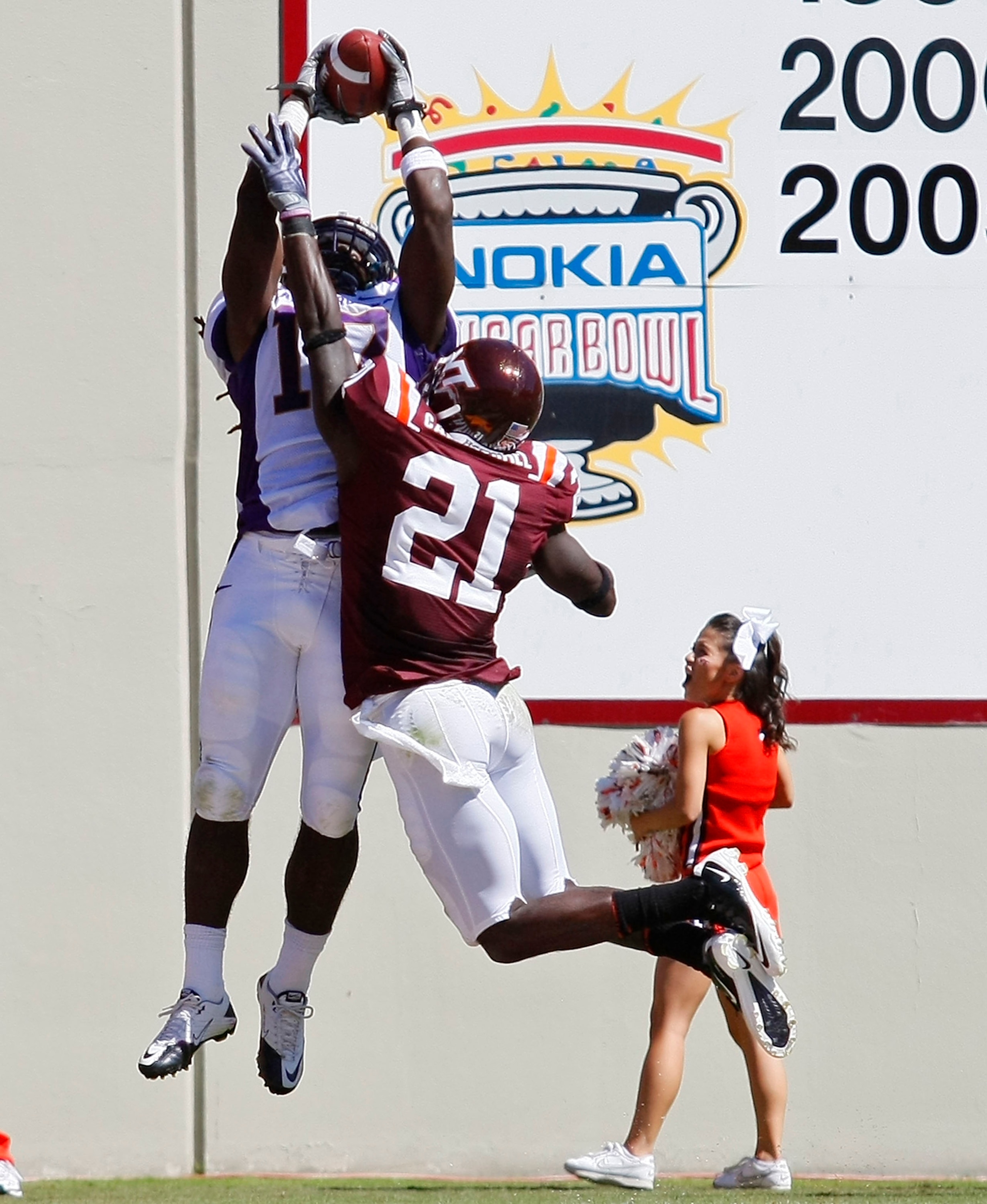 BLACKSBURG, VA - SEPTEMBER 18: Wide receiver Dwayne Harris #17 of the East Carolina Pirates leaps to catch a pass for a touchdown over cornerback Rashad Carmichael #21 of the Virginia Tech Hokies at Lane Stadium on September 18, 2010 in Blacksburg, Virgi BLACKSBURG, VA - SEPTEMBER 18: Wide receiver Dwayne Harris #17 of the East Carolina Pirates leaps to catch a pass for a touchdown over cornerback Rashad Carmichael #21 of the Virginia Tech Hokies at Lane Stadium on September 18, 2010 in Blacksburg, Virgi