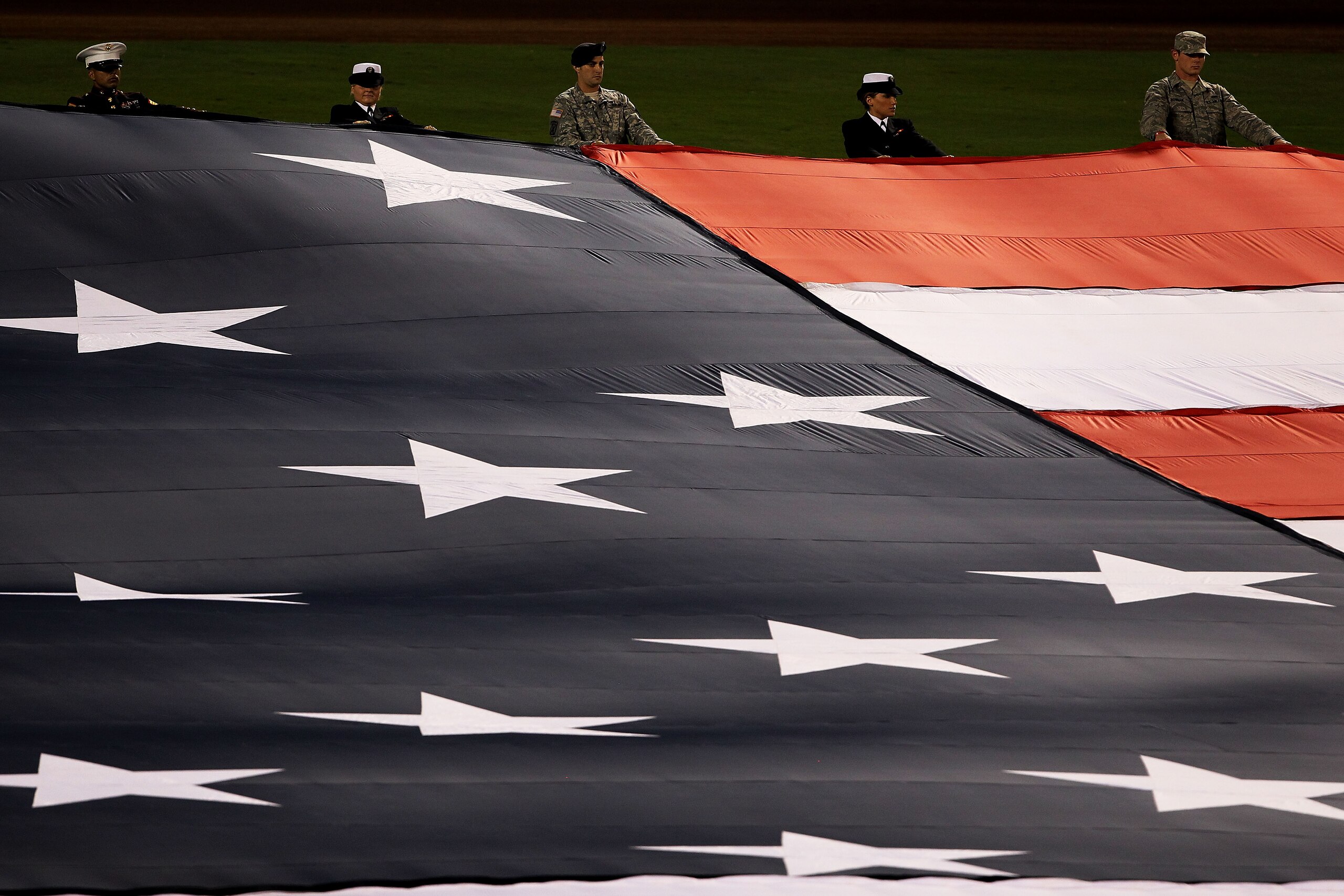 ARLINGTON, TX - OCTOBER 31: Military personnel hold a giant flag during the performance of the National Anthem prior to the Texas Rangers playing against the San Francisco Giants in Game Four of the 2010 MLB World Series at Rangers Ballpark in Arlington ARLINGTON, TX - OCTOBER 31: Military personnel hold a giant flag during the performance of the National Anthem prior to the Texas Rangers playing against the San Francisco Giants in Game Four of the 2010 MLB World Series at Rangers Ballpark in Arlington
