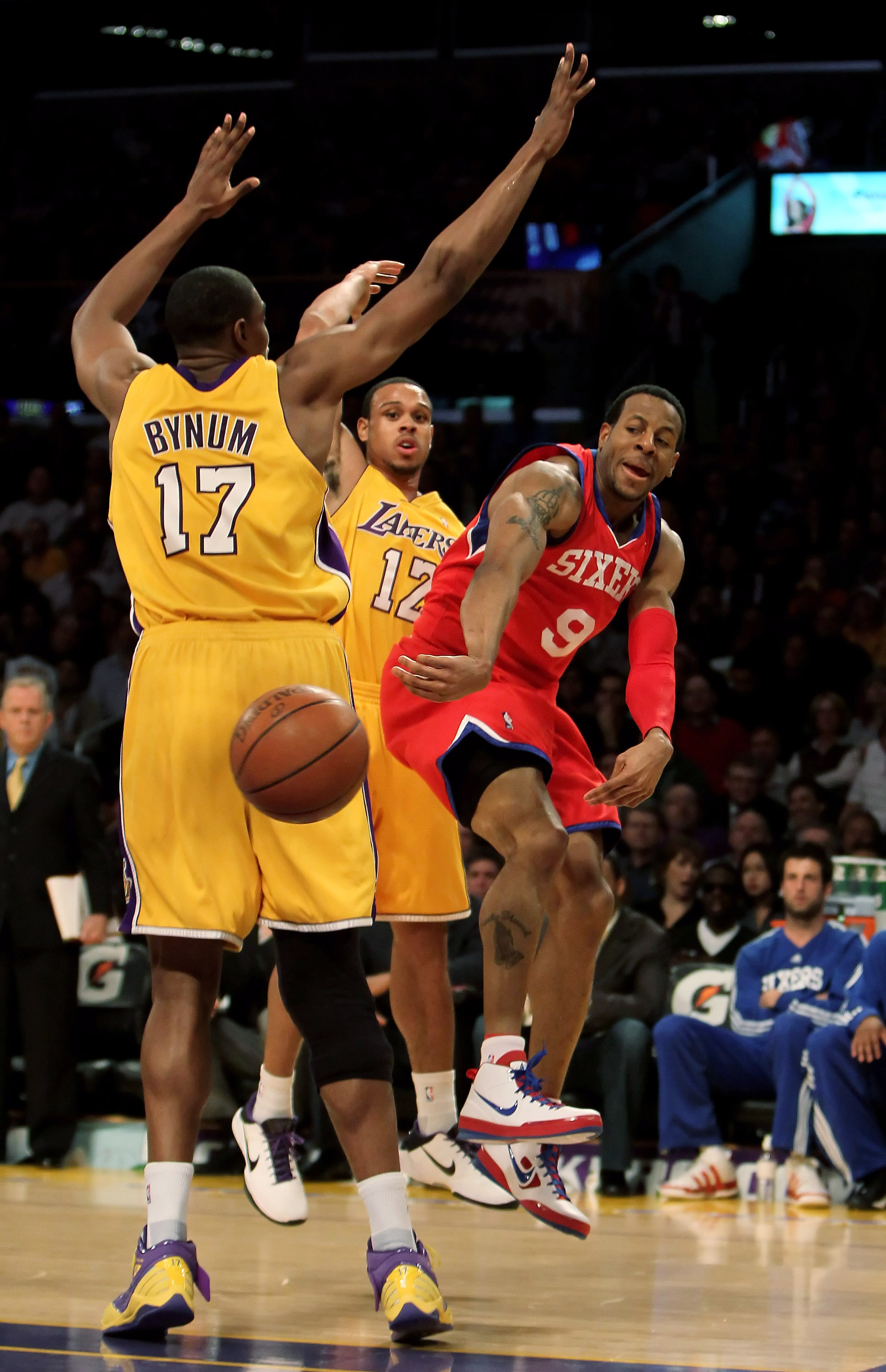 LOS ANGELES, CA - FEBRUARY 26:  Andre Iguodala #9 of the Philadelphia 76ers passes the ball around Andrew Bynum #17 of the Los Angeles Lakers in the first half at Staples Center on February 26, 2010 in Los Angeles, California. NOTE TO USER: User expressly