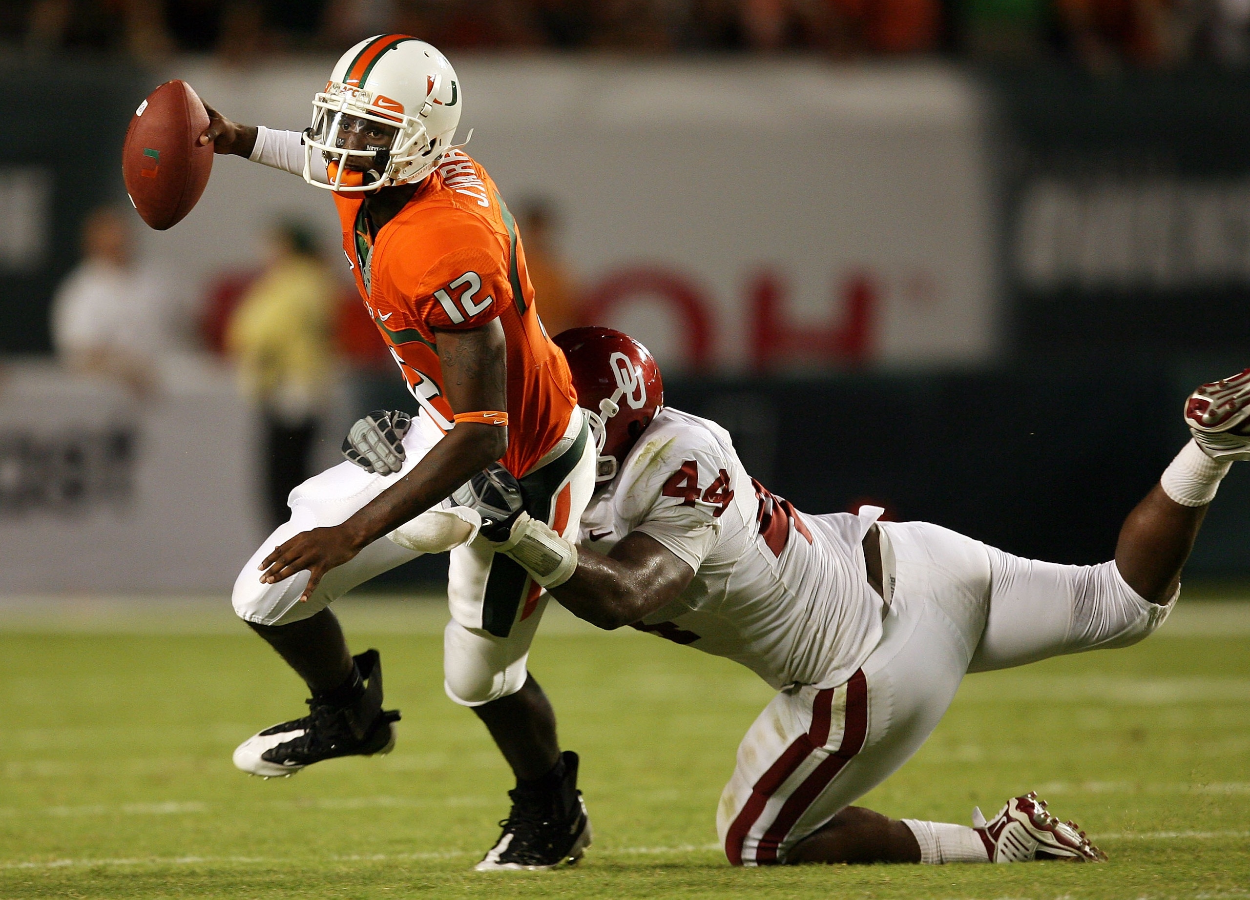FORT LAUDERDALE, FL - OCTOBER 03: Quarterback Jacory Harris #12 of the Miami Hurricanes is sacked by defensive end Jeremy Beal #44 of the Oklahoma Sooners at Land Shark Stadium on October 3, 2009 in Fort Lauderdale, Florida. Miami defeated Oklahoma 21-20.