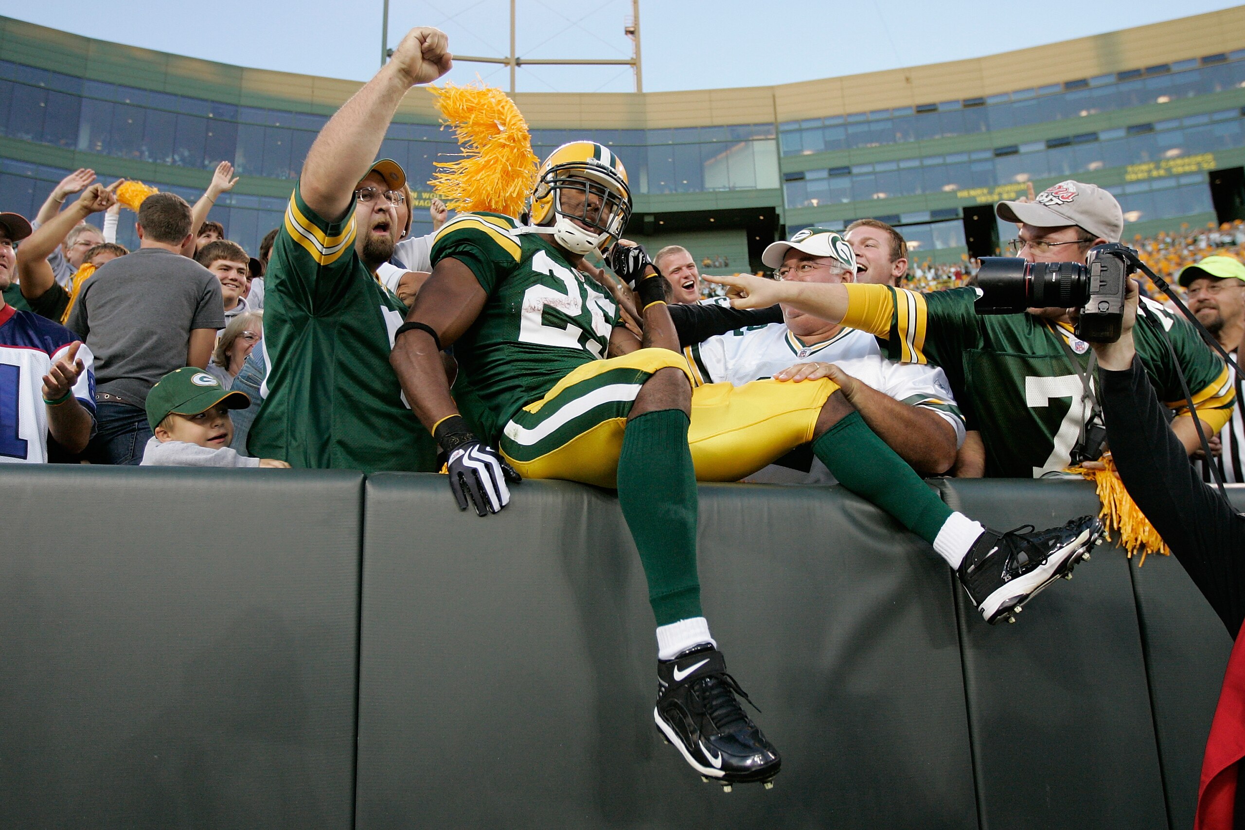 GREEN BAY, WI - AUGUST 22: Running back Ryan Grant #25 of the Green Bay Packers jumps in the stands to celebrate with fans after scoring a touchdown against the Buffalo Bills at Lambeau Field on August 22, 2009 in Green Bay. Wisconsin.  (Photo by Scott Bo