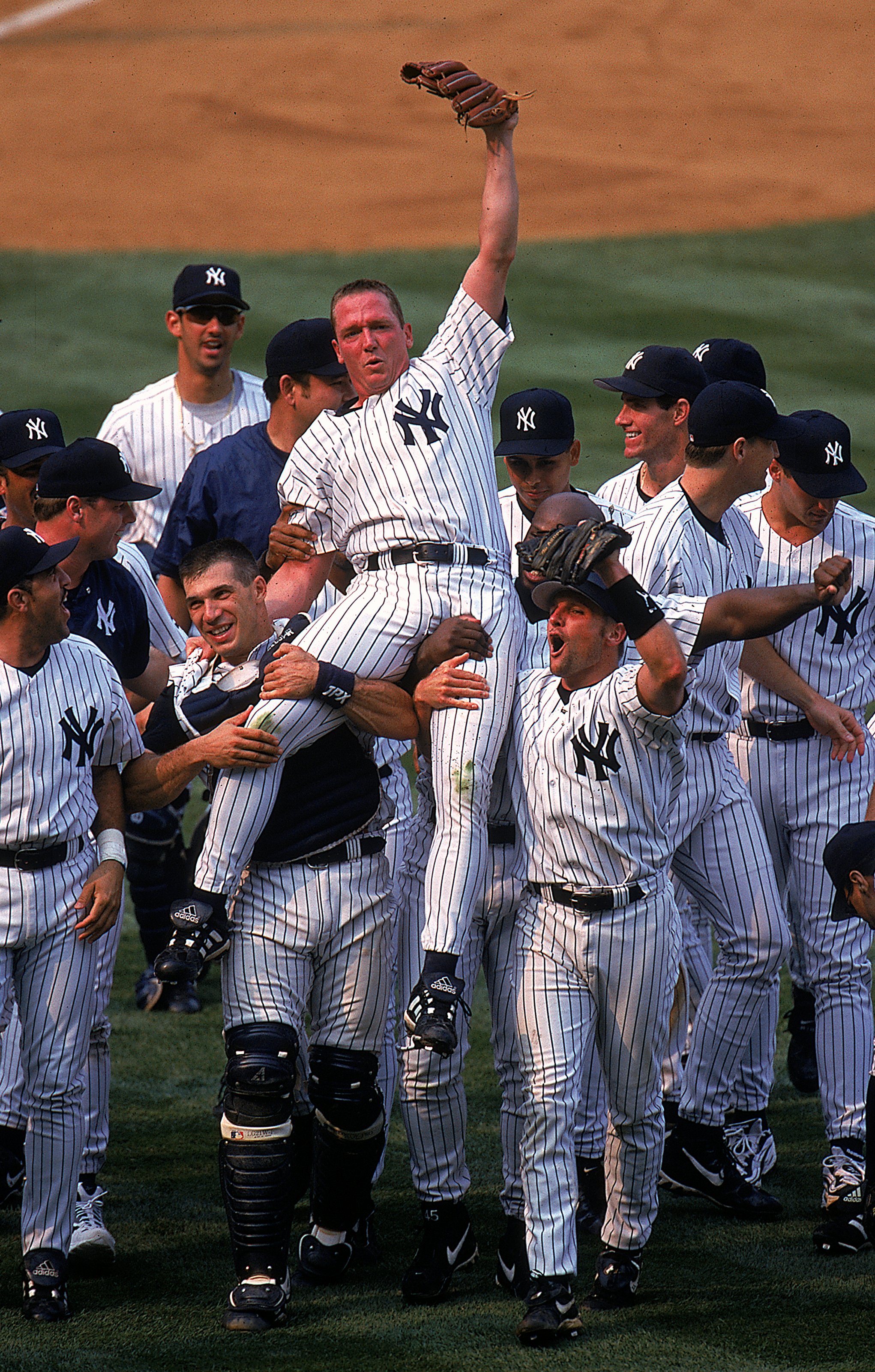 18 Jul 1999: David Cone #36 of the New York Yankees celebrates as his teammates lift him after winning the game against the Montreal Expos at Yankee Stadium in Bronx, New York. The Yankees defeated the Expos 6-0.