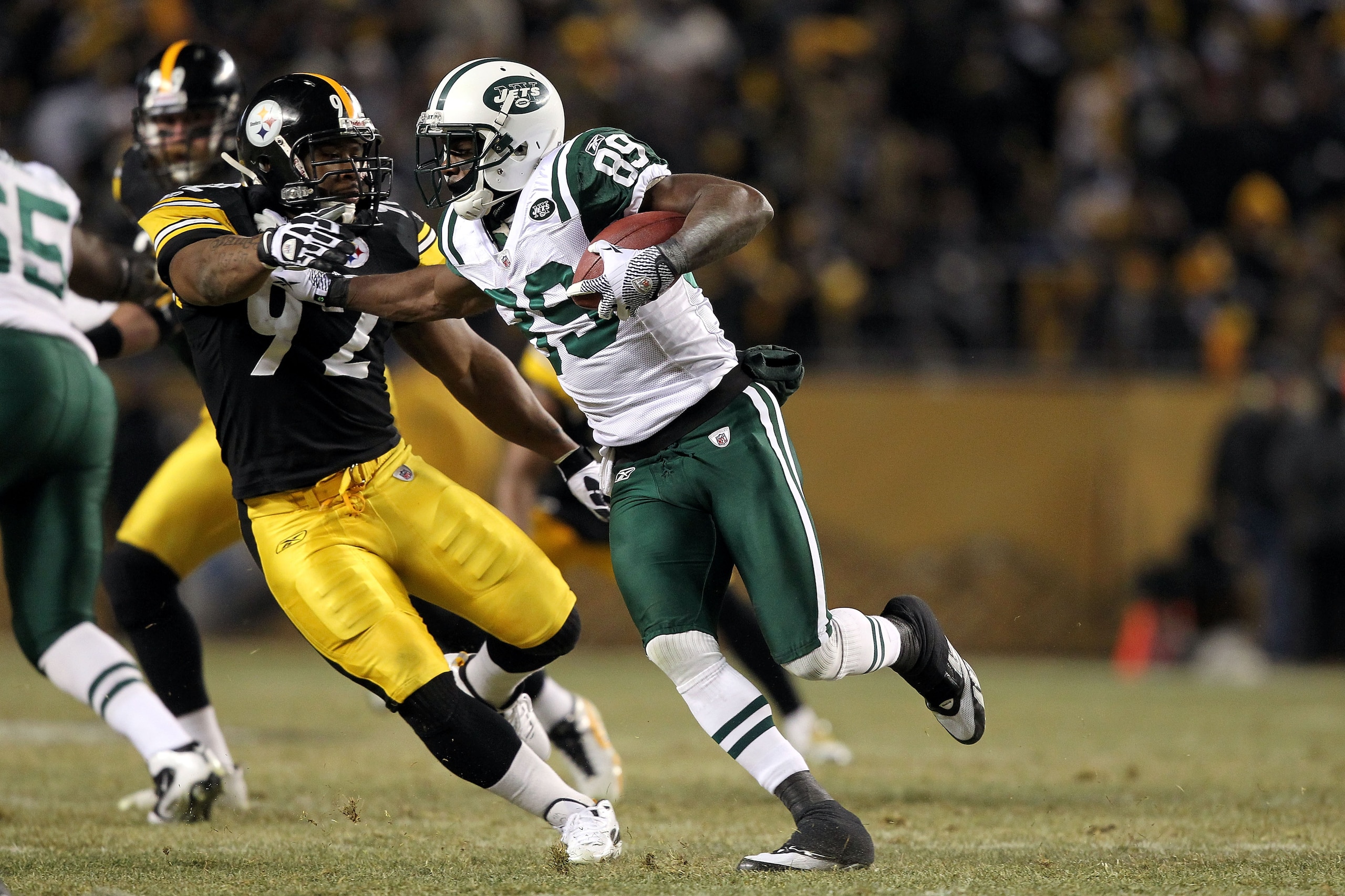 PITTSBURGH, PA - JANUARY 23:  Jerricho Cotchery #89 of the New York Jets runs with the ball against James Harrison #92 of the Pittsburgh Steelers during the 2011 AFC Championship game at Heinz Field on January 23, 2011 in Pittsburgh, Pennsylvania. The Ste