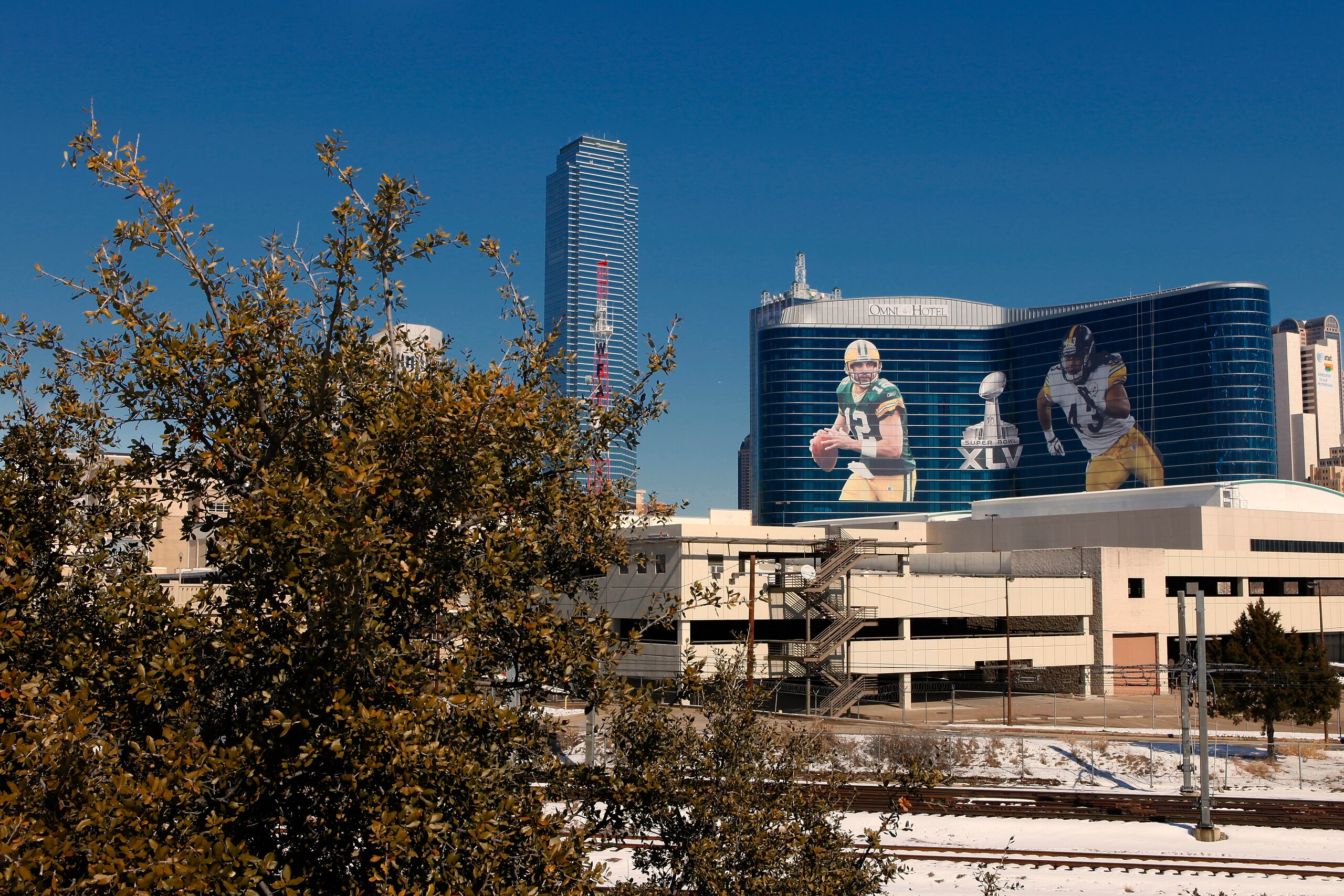 DALLAS, TX - FEBRUARY 5: General view of the downtown skyline with Super Bowl XLV art draped from the Omni Hotel on February 5, 2011 in Dallas, Texas. The Green Bay Packers will play the Pittsburgh Steelers in Super Bowl XLV on February 6, 2011 at Cowboys DALLAS, TX - FEBRUARY 5: General view of the downtown skyline with Super Bowl XLV art draped from the Omni Hotel on February 5, 2011 in Dallas, Texas. The Green Bay Packers will play the Pittsburgh Steelers in Super Bowl XLV on February 6, 2011 at Cowboys