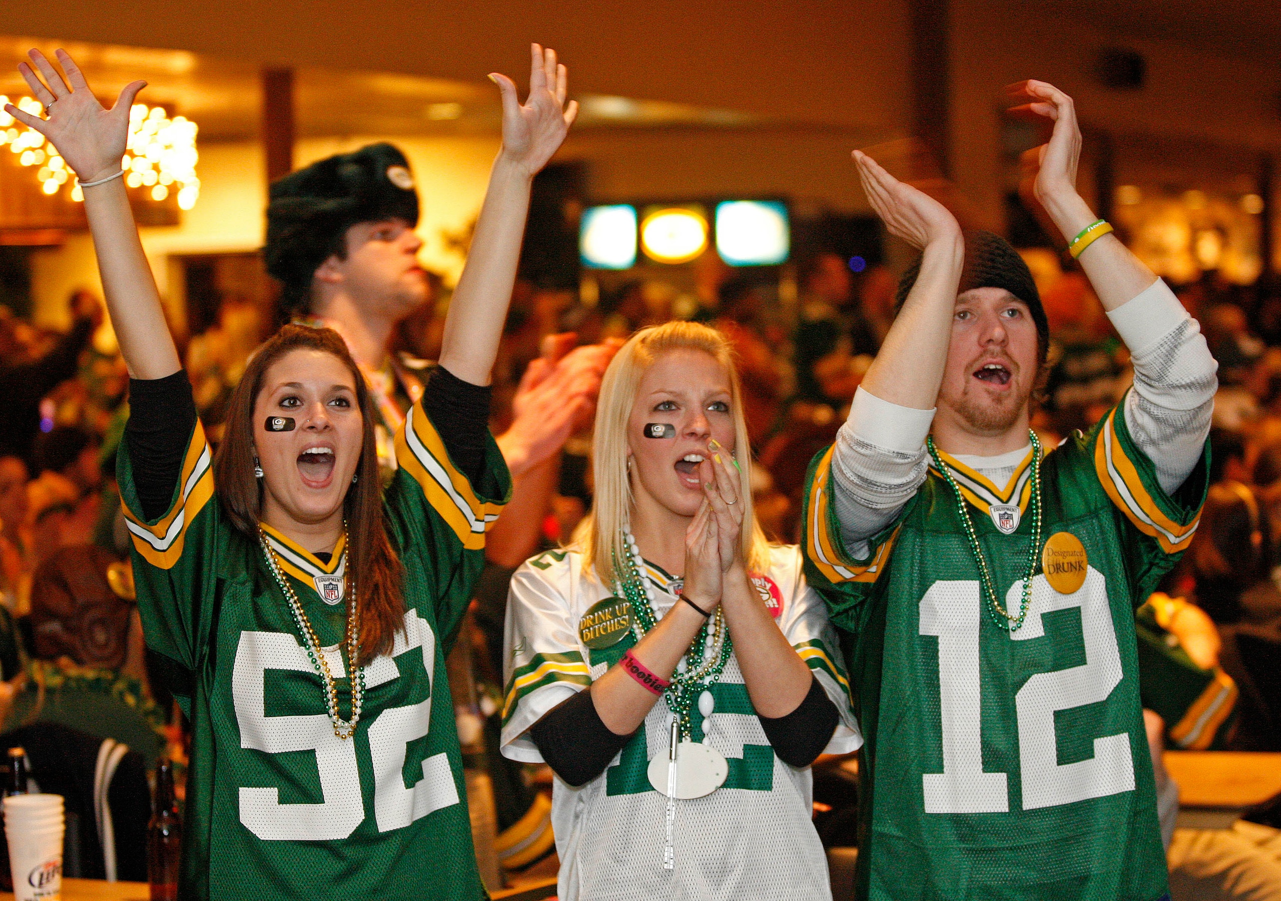 GREEN BAY, WI - FEBRUARY 06: Green Bay Packers fans Kelsey Brabender, Daisy Gresen, and Dylan Palchik react to a play while watching the Super Bowl at Stadium View Bar on February 6, 2011 in Green Bay, Wisconsin.  (Photo by Matt Ludtke/Getty Images)