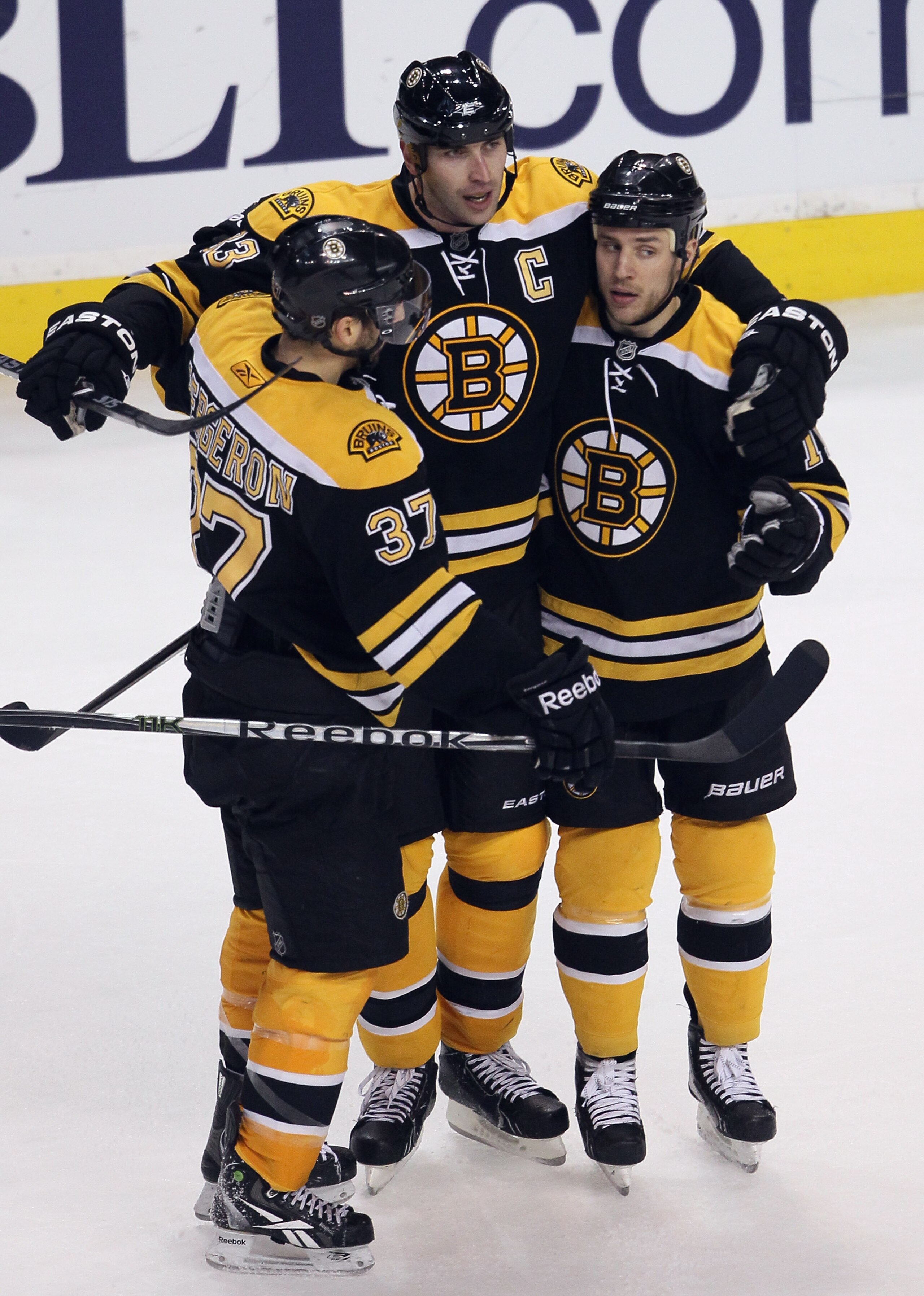 BOSTON, MA - JANUARY 13: Gregory Campbell #11 of the Boston Bruins is congratulated by teammates Zdeno Chara #33 and Patrice Bergeron #37 after Campbell scored an empty net goal in the third period against the Philadelphia Flyers on January 13, 2011 at th