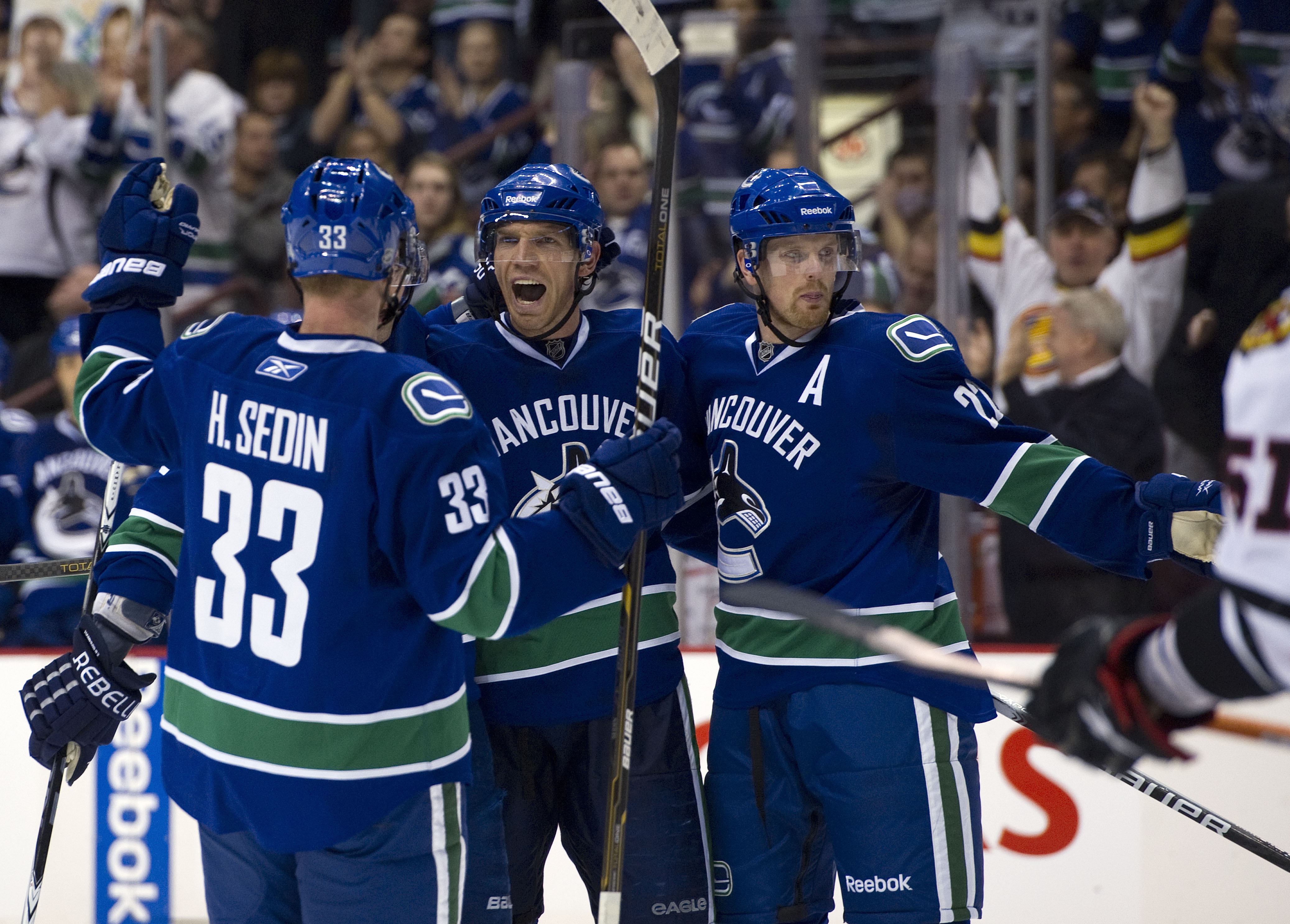 VANCOUVER, CANADA - JANUARY 4: Mikael Samuelsson #26 of the Vancouver Canucks celebrates with Henrik Sedin #33 and Daniel Sedin #22 after scoring against the Chicago Blackhawks during the second period in NHL action on February 04, 2011 at Rogers Arena in