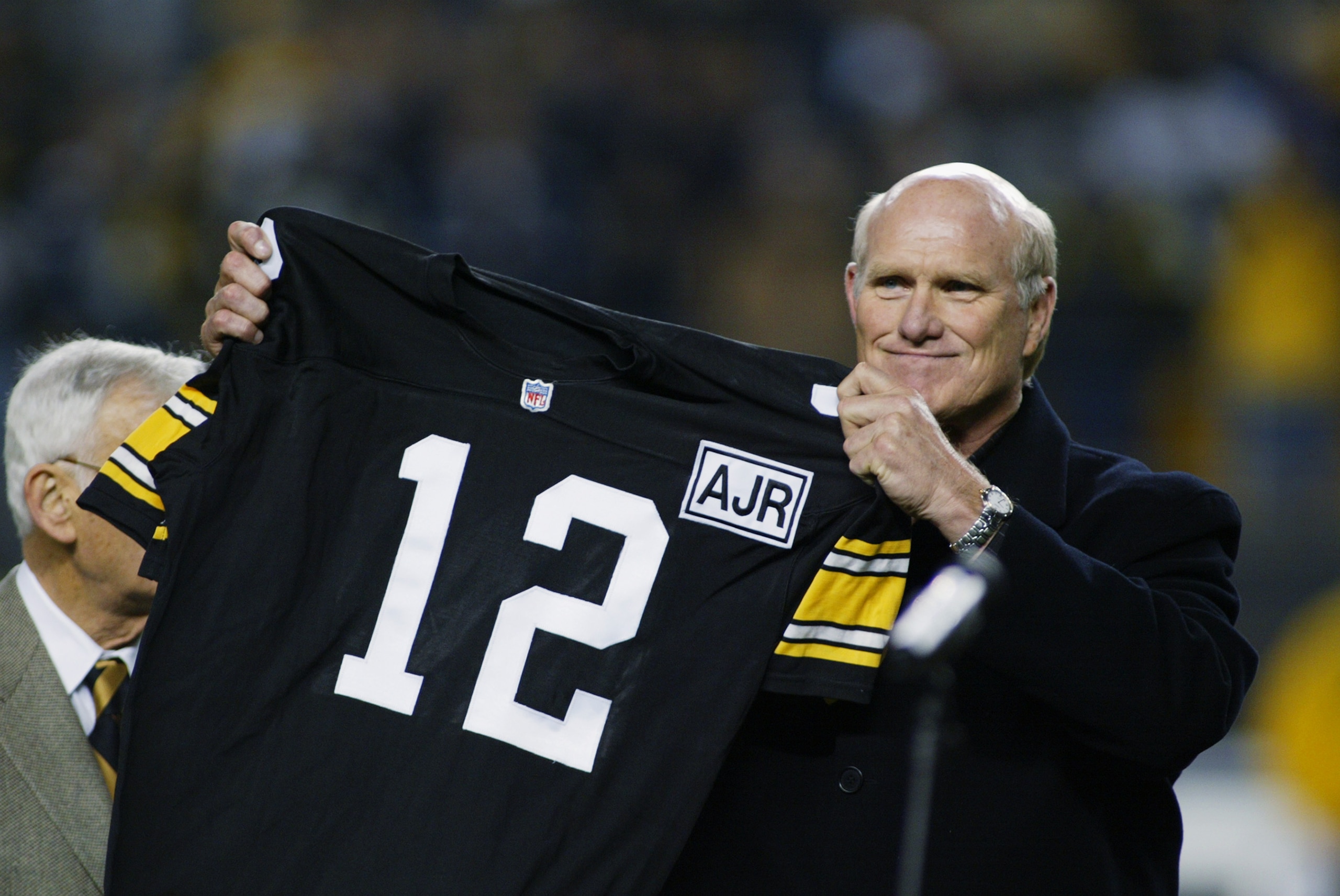 PITTSBURGH, PA - OCTOBER 21:   Retired Quarterback Terry Bradshaw of the Pittsburgh Steelers holds up his old number during the NFL game against the Indianapolis Colts at Heinz Field on October 21, 2002 in Pittsburgh, Pennsylvania. Pittsburgh won 28-10.(P