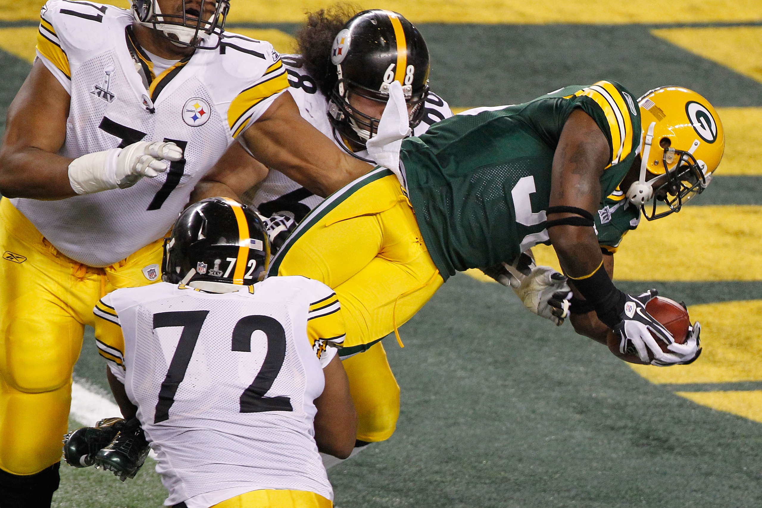 ARLINGTON, TX - FEBRUARY 06: Nick Collins #36 of the Green Bay Packers runs 37 yards for a touchdown after making an interception as he is tackled by Jonathan Scott #72 and Chris Kemoeatu #68 of the Pittsburgh Steelers in the first quarter against the Pi ARLINGTON, TX - FEBRUARY 06: Nick Collins #36 of the Green Bay Packers runs 37 yards for a touchdown after making an interception as he is tackled by Jonathan Scott #72 and Chris Kemoeatu #68 of the Pittsburgh Steelers in the first quarter against the Pi