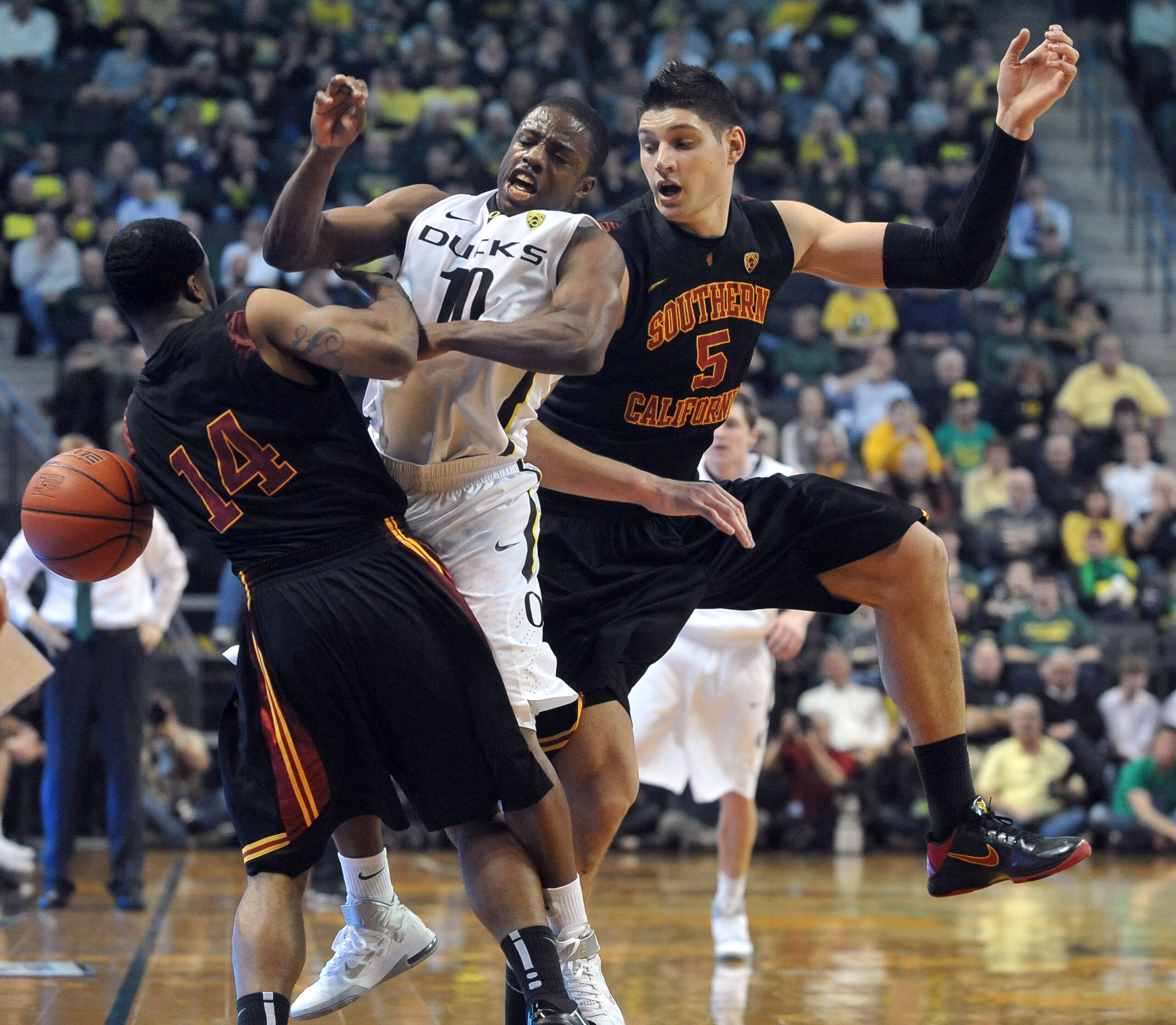 EUGENE, OR - JANUARY 13: Donte Smith (14) and Nikola Vucevic (5) of the USC Trojans pressure Johnathan Loyd (10) of the Oregon Ducks during the second half of the game at Matthew Knight Arena on January 13, 2011 in Eugene, Oregon. Oregon won the game 68-6
