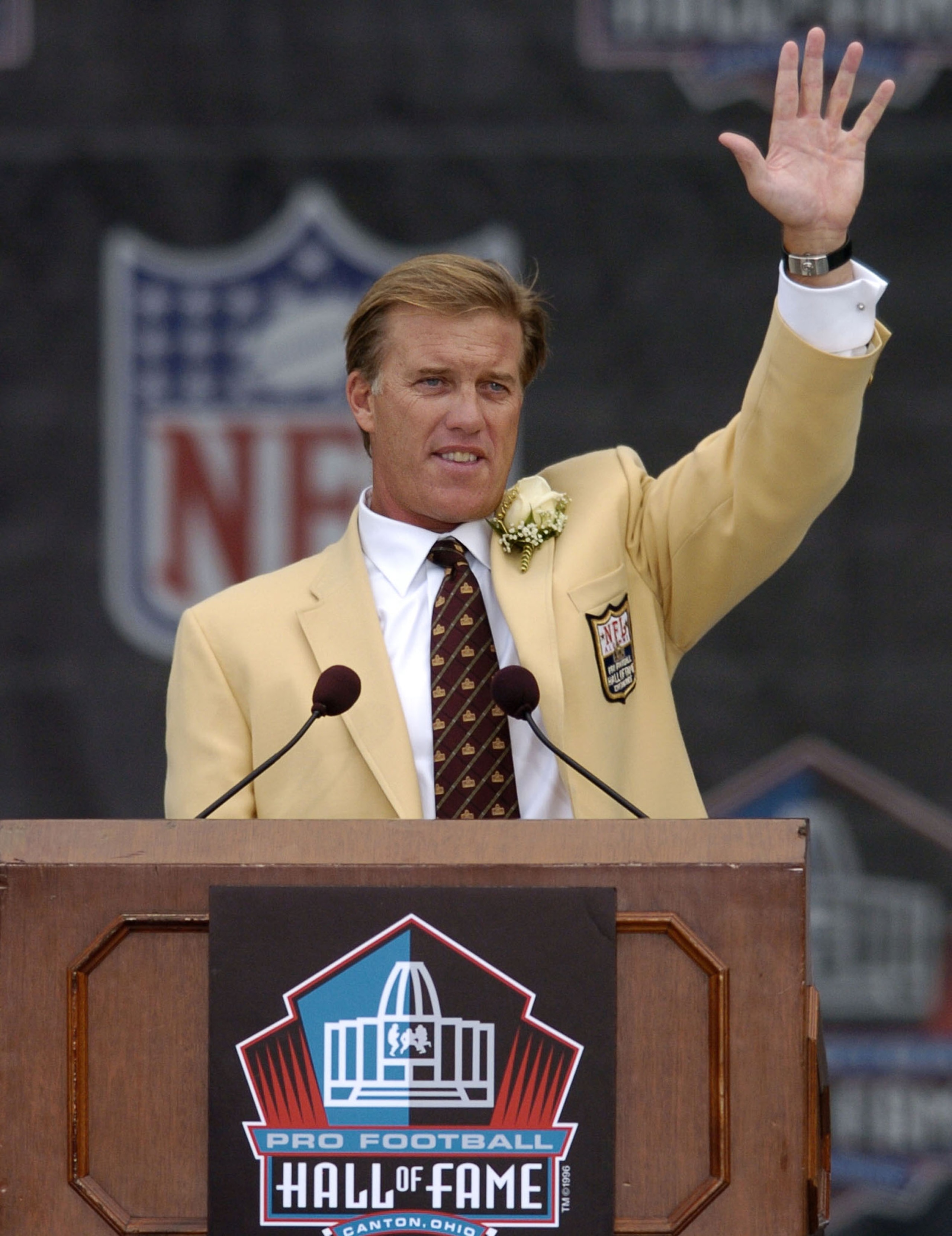 CANTON, OH - AUGUST 8:  Pro Football Hall of Fame enshrinee John Elway waves to the crowd during the 2004 NFL Hall of Fame enshrinement ceremony on August 8, 2004 in Canton, Ohio.  (Photo by David Maxwell/Getty Images)