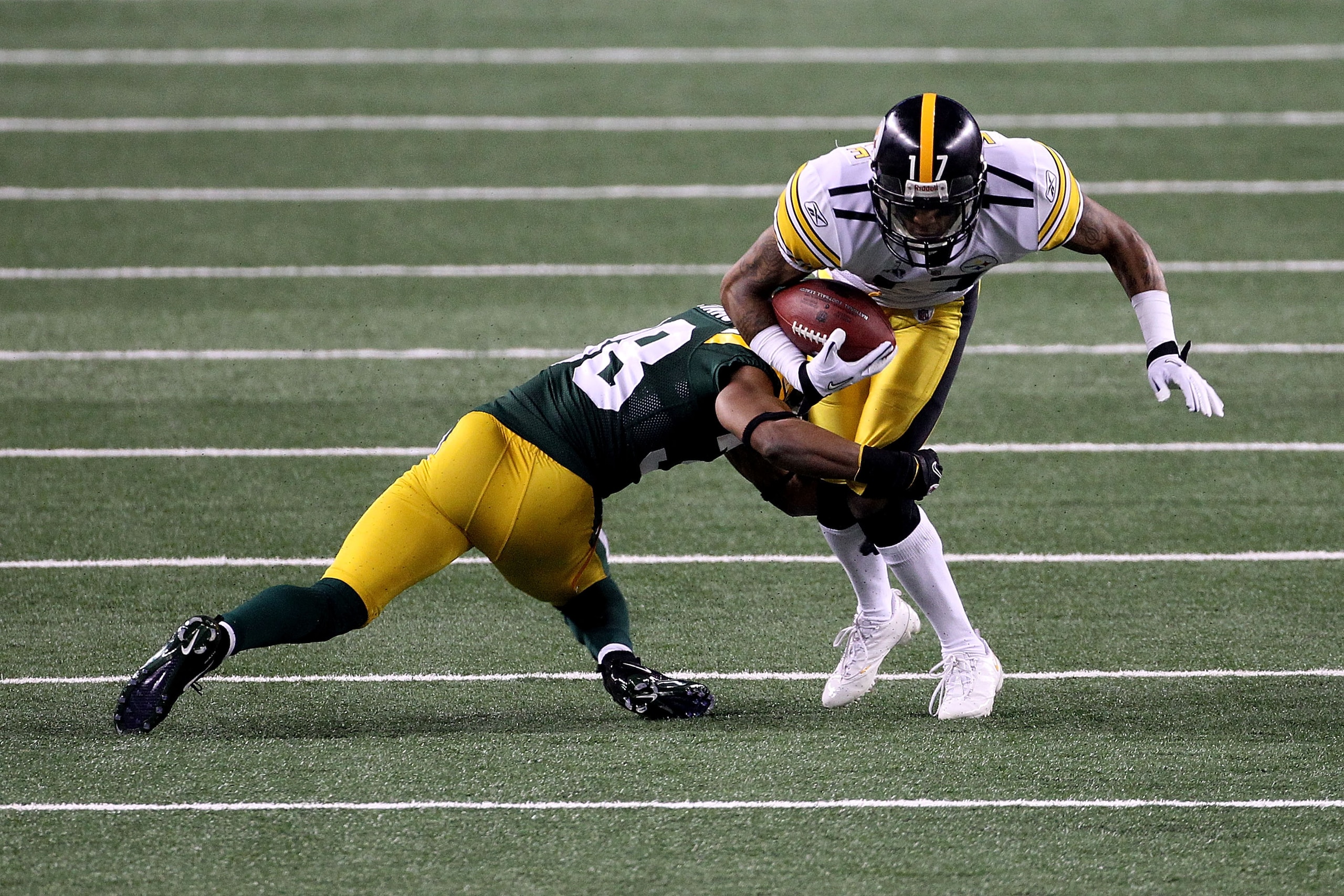 ARLINGTON, TX - FEBRUARY 06: Mike Wallace #17 of the Pittsburgh Steelers is tackled by Tramon Williams #38 of the Green Bay Packers during the first quarter of Super Bowl XLV at Cowboys Stadium on February 6, 2011 in Arlington, Texas.  (Photo by Streeter