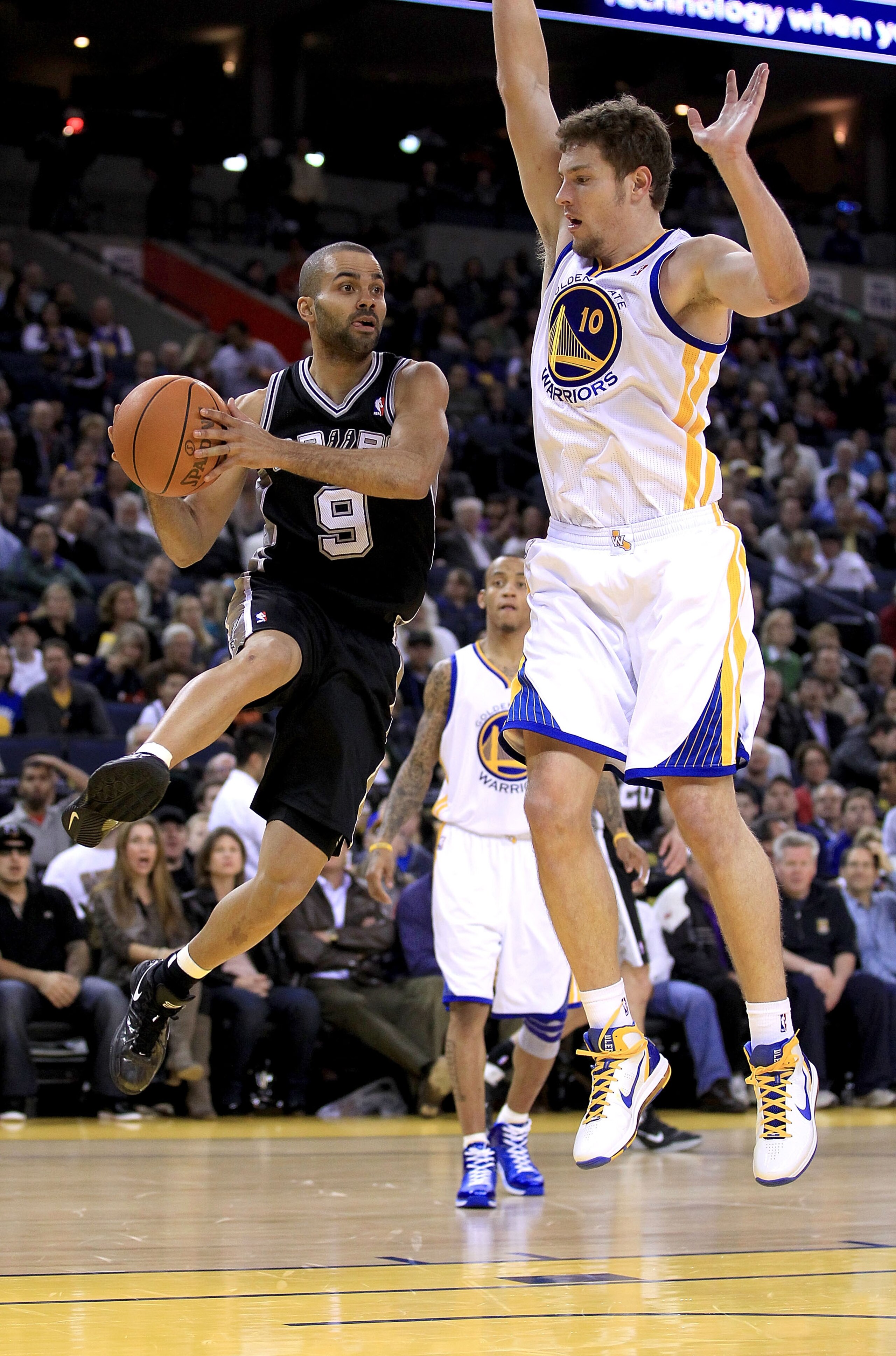OAKLAND, CA - JANUARY 24:  Tony Parker #9 of the San Antonio Spurs drives on David Lee #10 of the Golden State Warriors at Oracle Arena on January 24, 2011 in Oakland, California.  NOTE TO USER: User expressly acknowledges and agrees that, by downloading