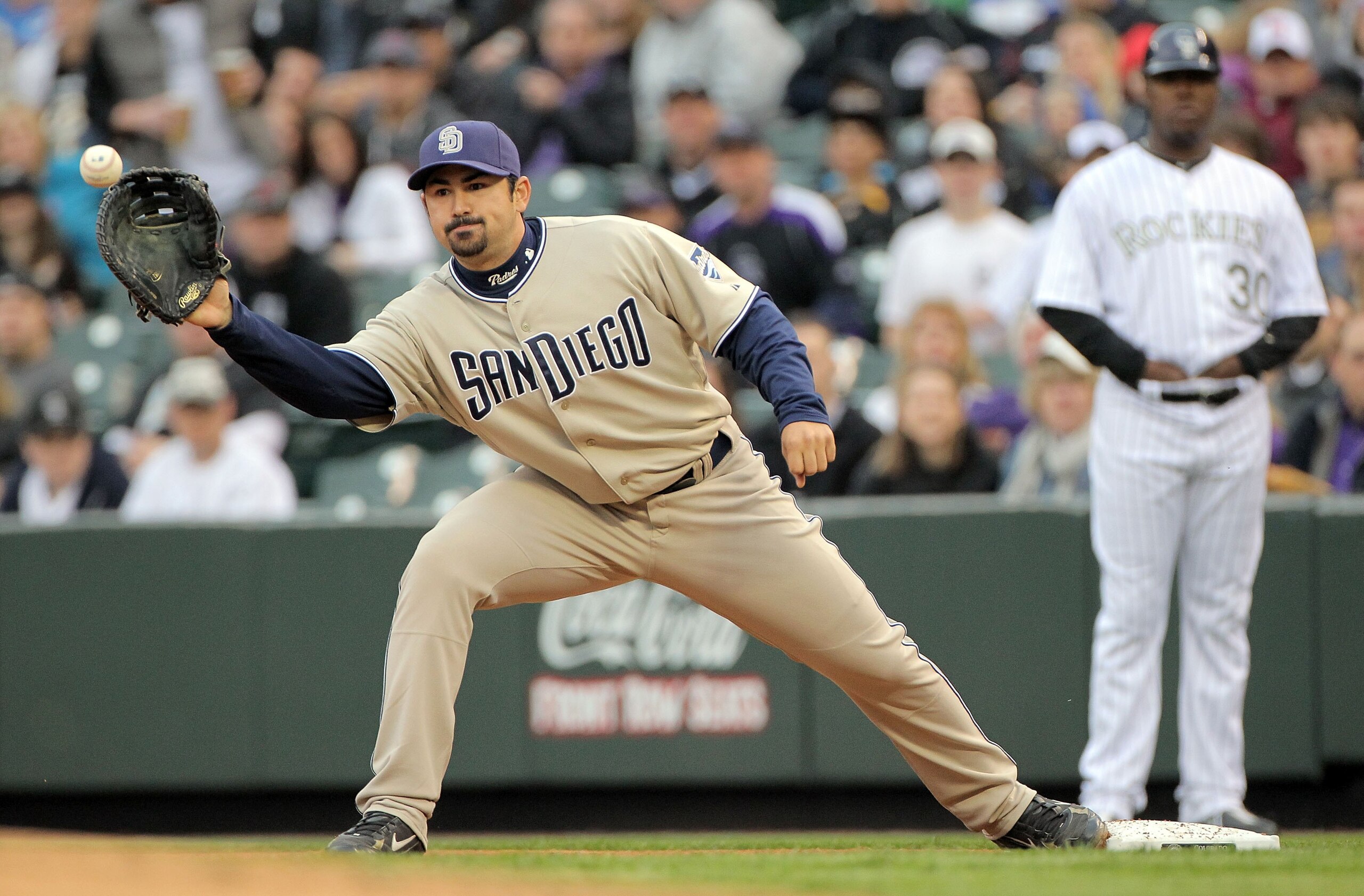 DENVER - APRIL 10: First baseman Adrian Gonzalez #23 of the San Diego Padres takes a throw at first base for a put out against the Colorado Rockies during MLB action at Coors Field on April 10, 2010 in Denver, Colorado. The Padres defeated the Rockies 5- DENVER - APRIL 10: First baseman Adrian Gonzalez #23 of the San Diego Padres takes a throw at first base for a put out against the Colorado Rockies during MLB action at Coors Field on April 10, 2010 in Denver, Colorado. The Padres defeated the Rockies 5-