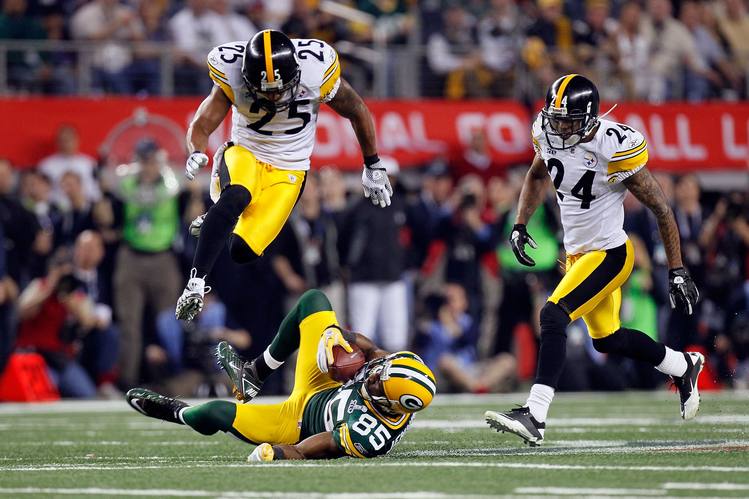 ARLINGTON, TX - FEBRUARY 06:  Greg Jennings #85 of the Green Bay Packers catches a 31 yard pass in the fourth quarter against Ryan Clark #25 and Ike Taylor #24 of the Pittsburgh Steelers during Super Bowl XLV at Cowboys Stadium on February 6, 2011 in Arli