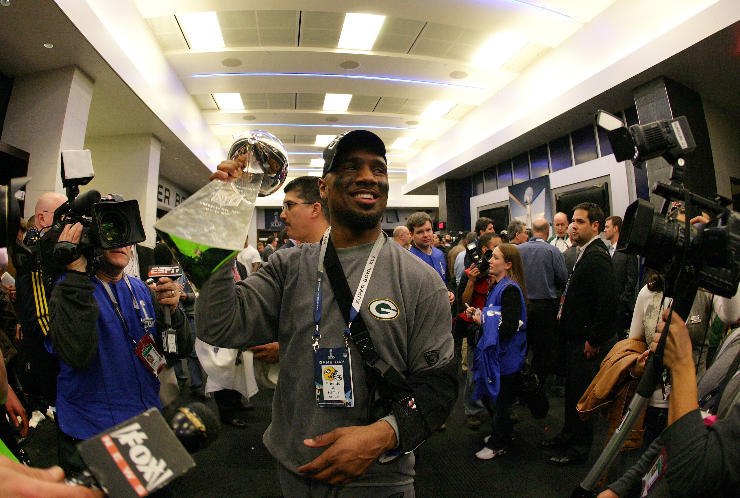 ARLINGTON, TX - FEBRUARY 06: Charles Woodson #21 of the Green Bay Packers celebrates in the locker room with the Vince Lombardi Trophy after winning Super Bowl XLV 31-25 against the Pittsburgh Steelers at Cowboys Stadium on February 6, 2011 in Arlington,