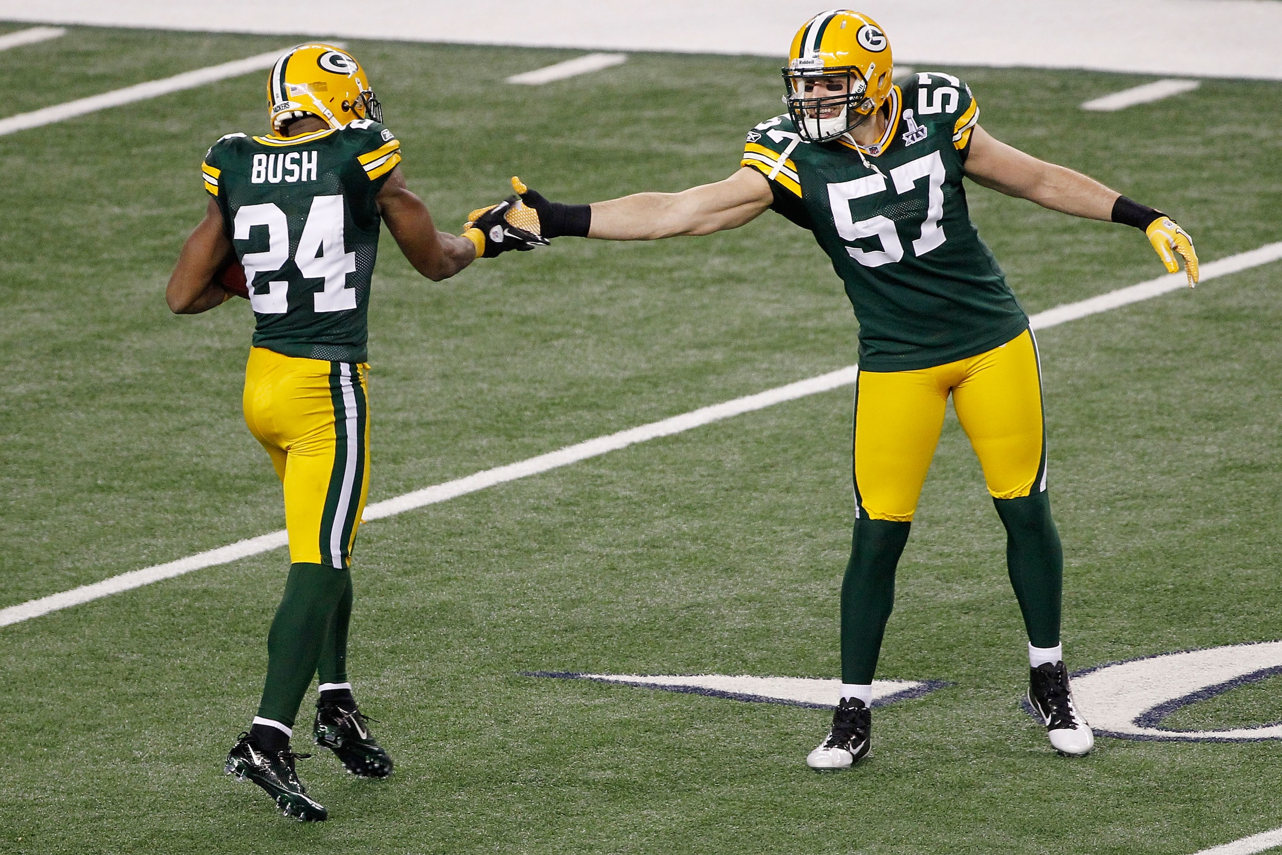 ARLINGTON, TX - FEBRUARY 06:  Jarrett Bush #24 celebrates with Matt Wilhelm #57 of the Green Bay Packers after a second quarter interception against the Pittsburgh Steelers during Super Bowl XLV at Cowboys Stadium on February 6, 2011 in Arlington, Texas.